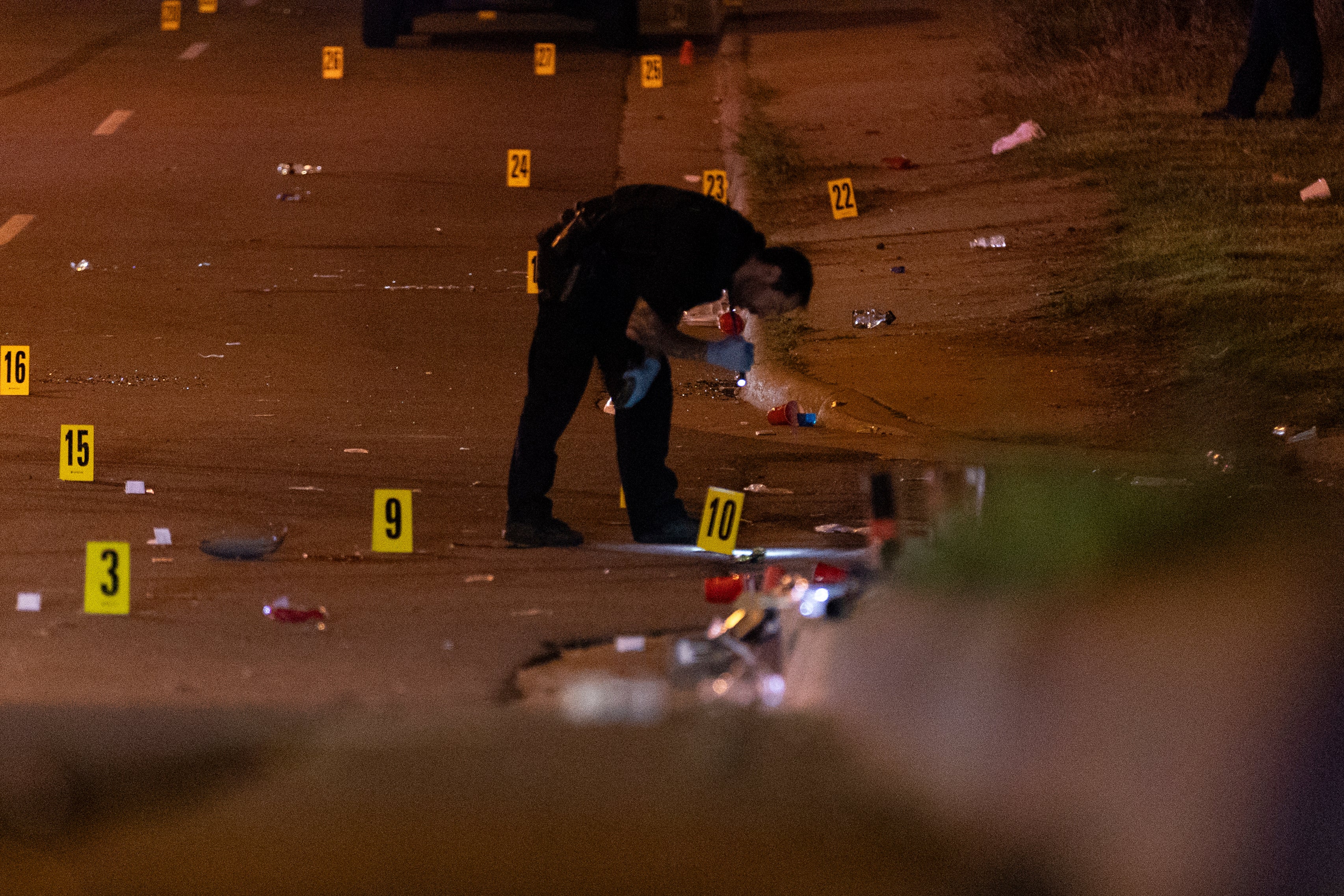 A police officer pictured at the scene of a shooting in Akron, Ohio on Sunday. Police say one person is dead and two dozen are injured