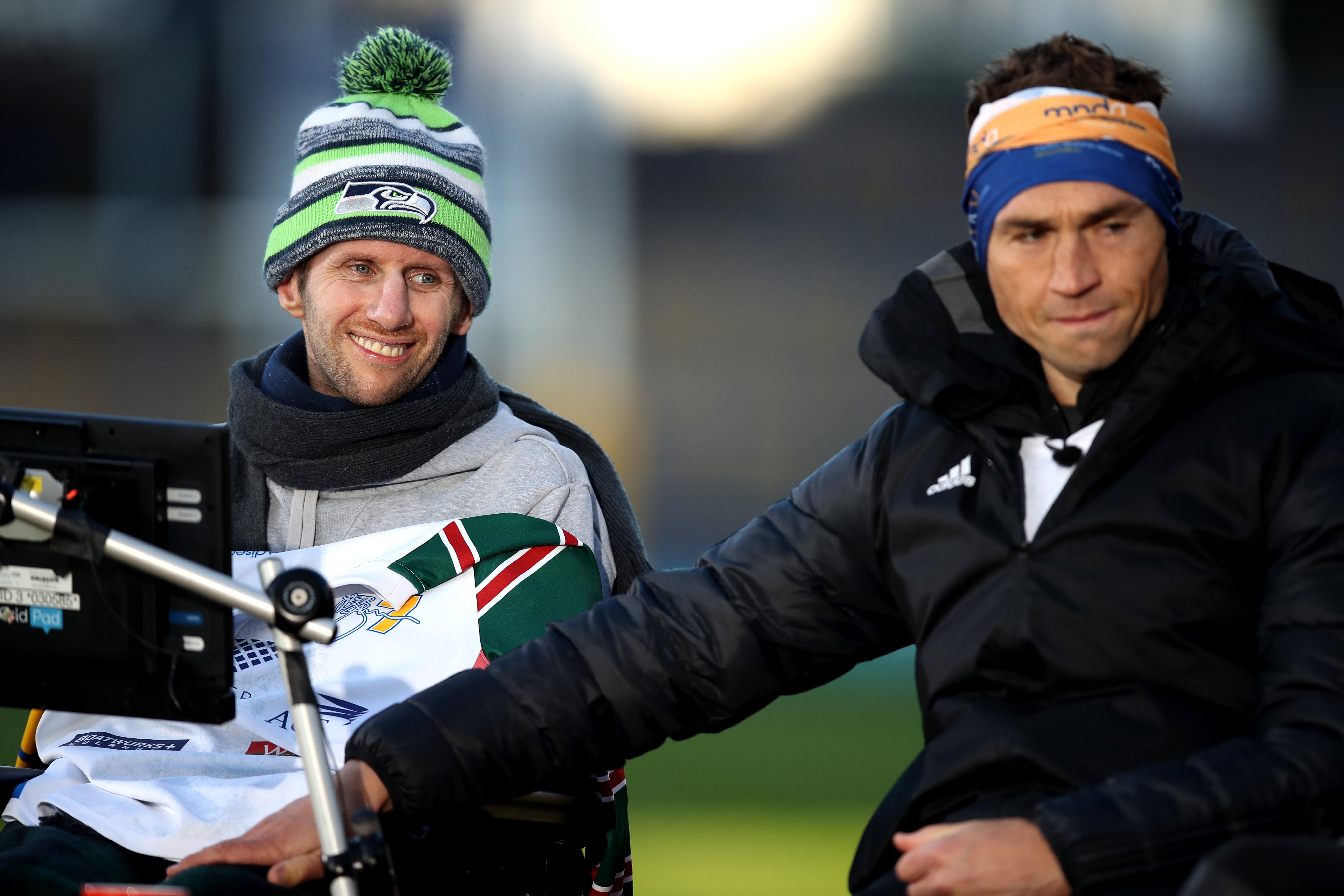 Ex-Leeds Rhinos rugby league player Kevin Sinfield (R) embraces former teammate Rob Burrow