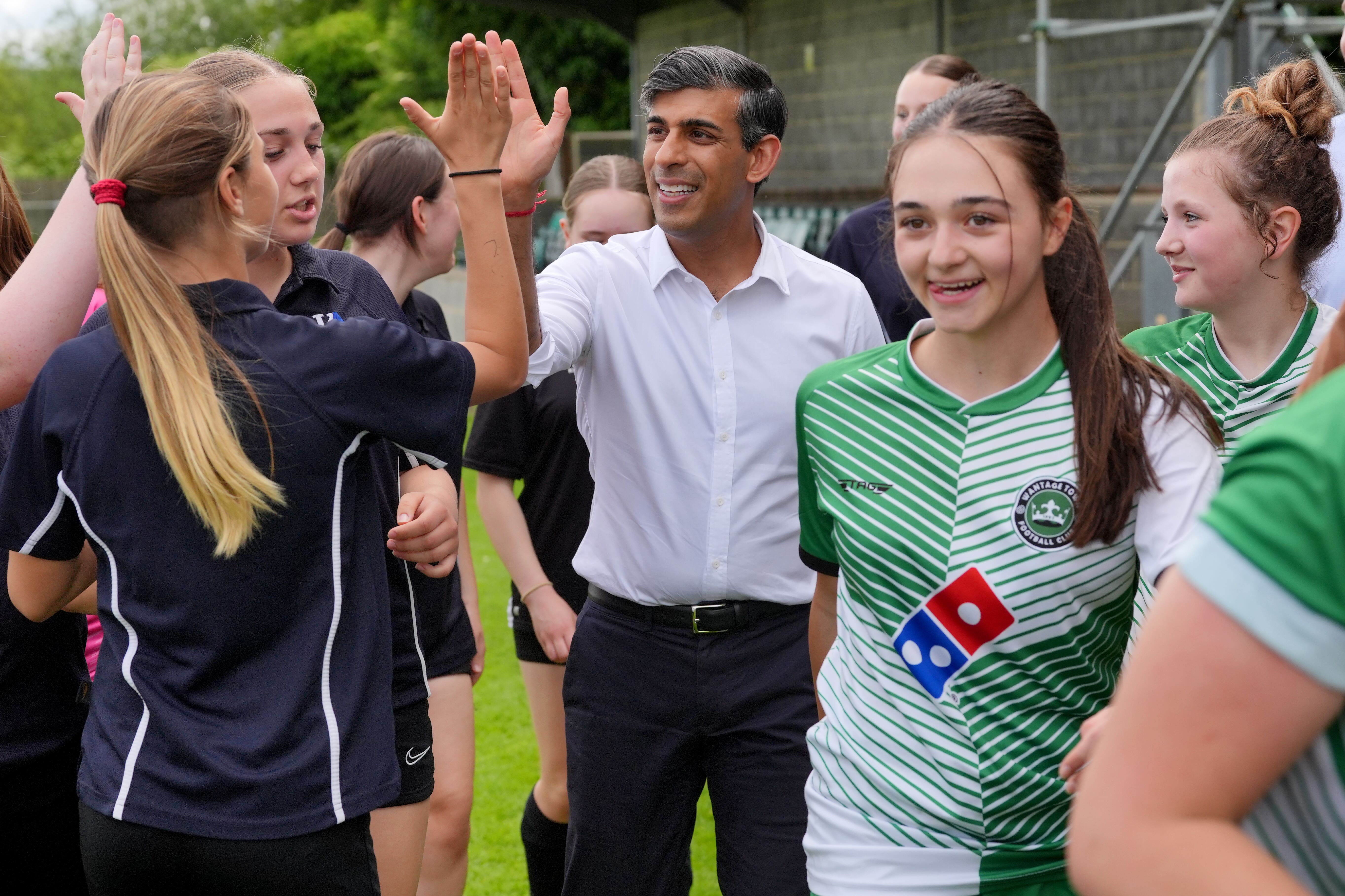 Prime Minister Rishi Sunak exchanges high fives with a member of Wantage Town Football Club during a visit to the club in Oxfordshire (Jonathan Brady/PA)