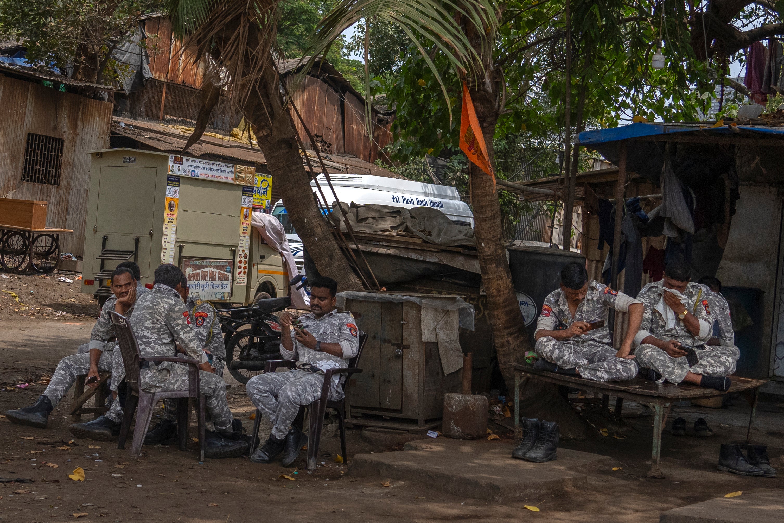 Soldiers sit under the shade of a tree outside a vote-counting centre in Mumbai on Monday