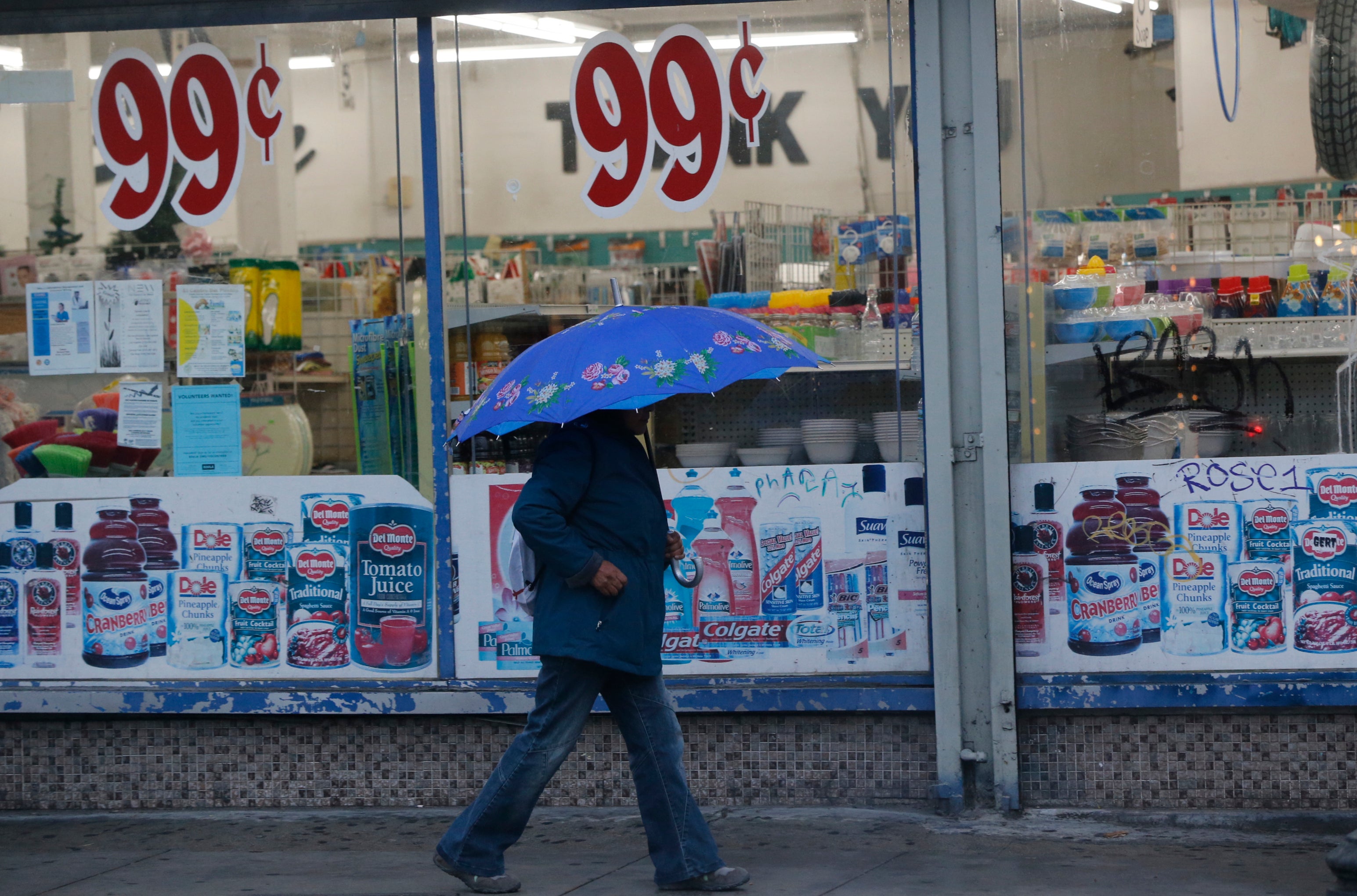 A pedestrian walks past a 99 Cents Only store under light rain in Los Angeles Wednesday, Dec. 5, 2018.