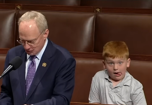 Representative John Rose (R-Tenn.) gives a speech on June 3, 2024, at the House of Representatives, while his son Guy makes funny faces behind him