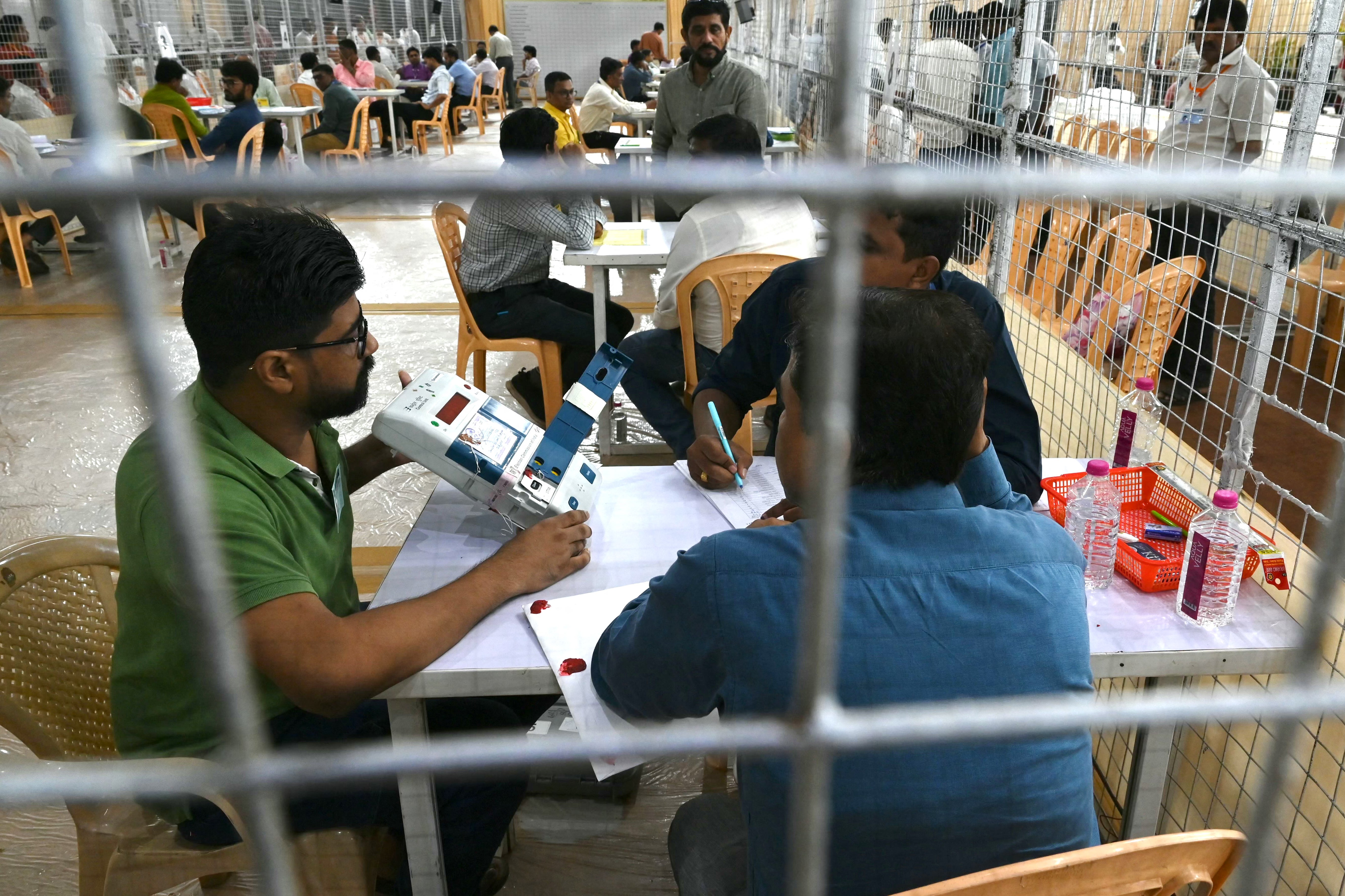 Election workers count votes from an electronic voting machine in Mumbai