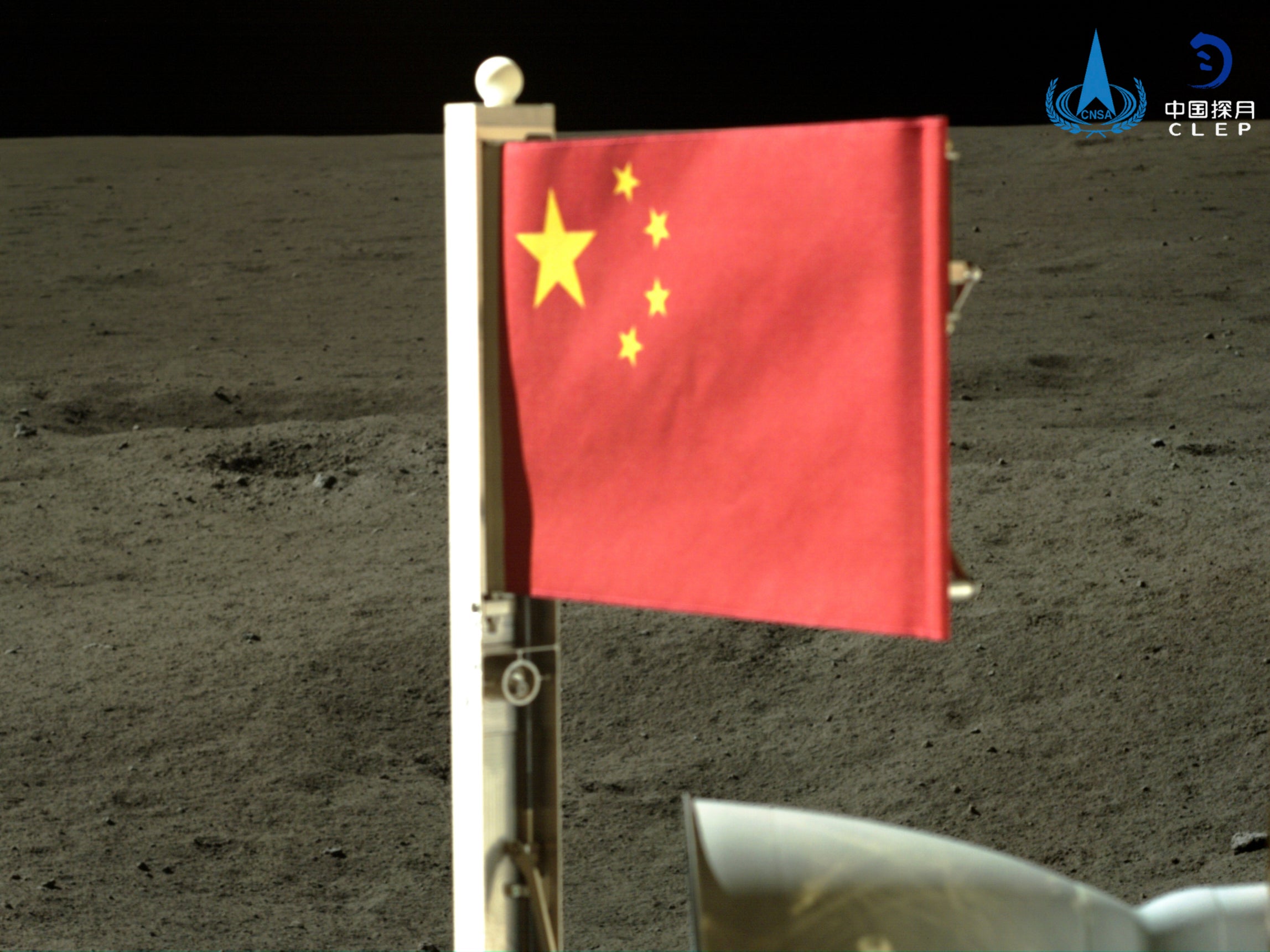 In this China National Space Administration handout image released by Xinhua News Agency, a Chinese national flag carried by the lander of Chang’e-6 probe unfurls on the moon’s far side