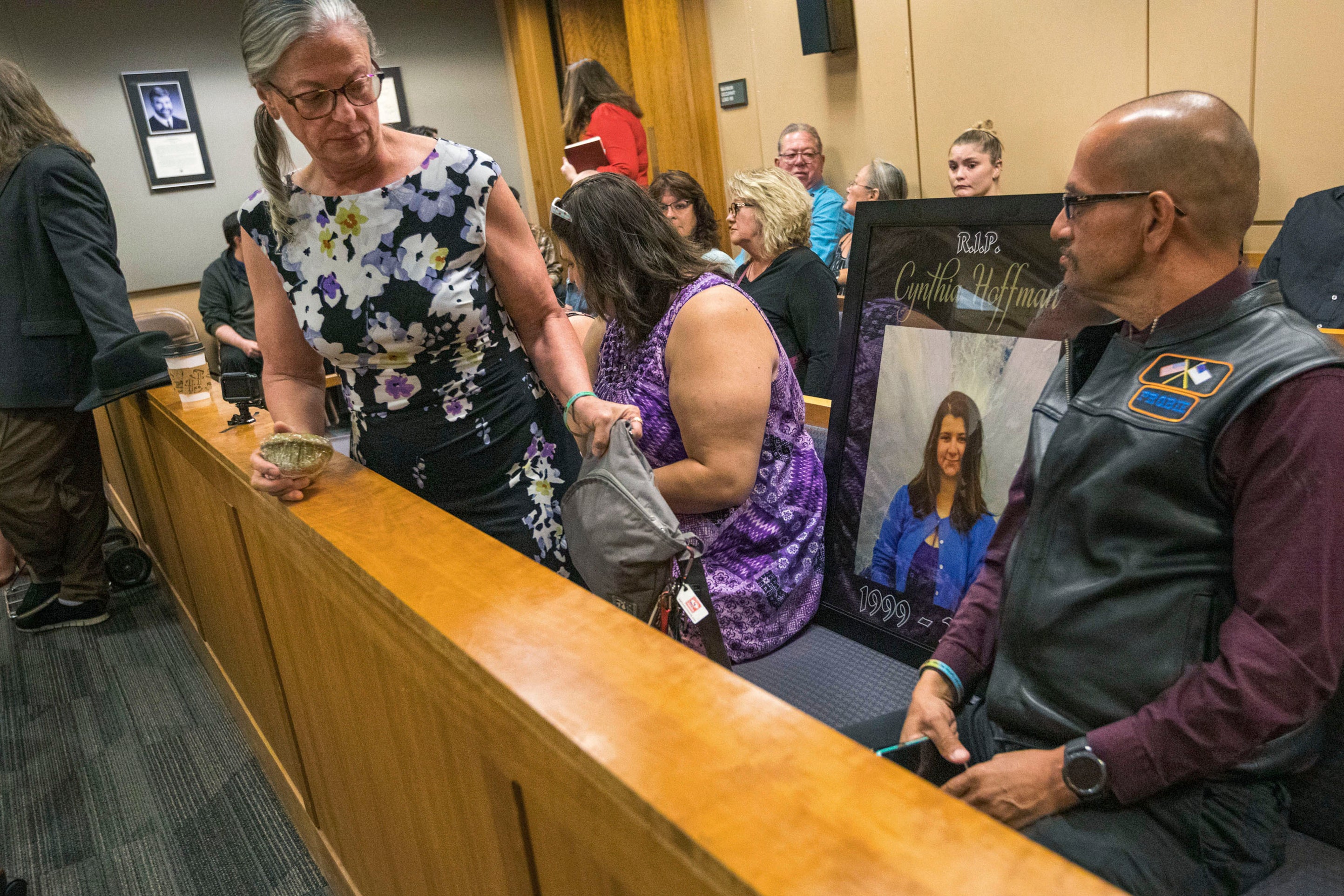 In 2019, Timothy Hoffman, right, sits next to a picture of his daughter Cynthia Hoffman, during Darin Schilmiller's arraignment for murder charges