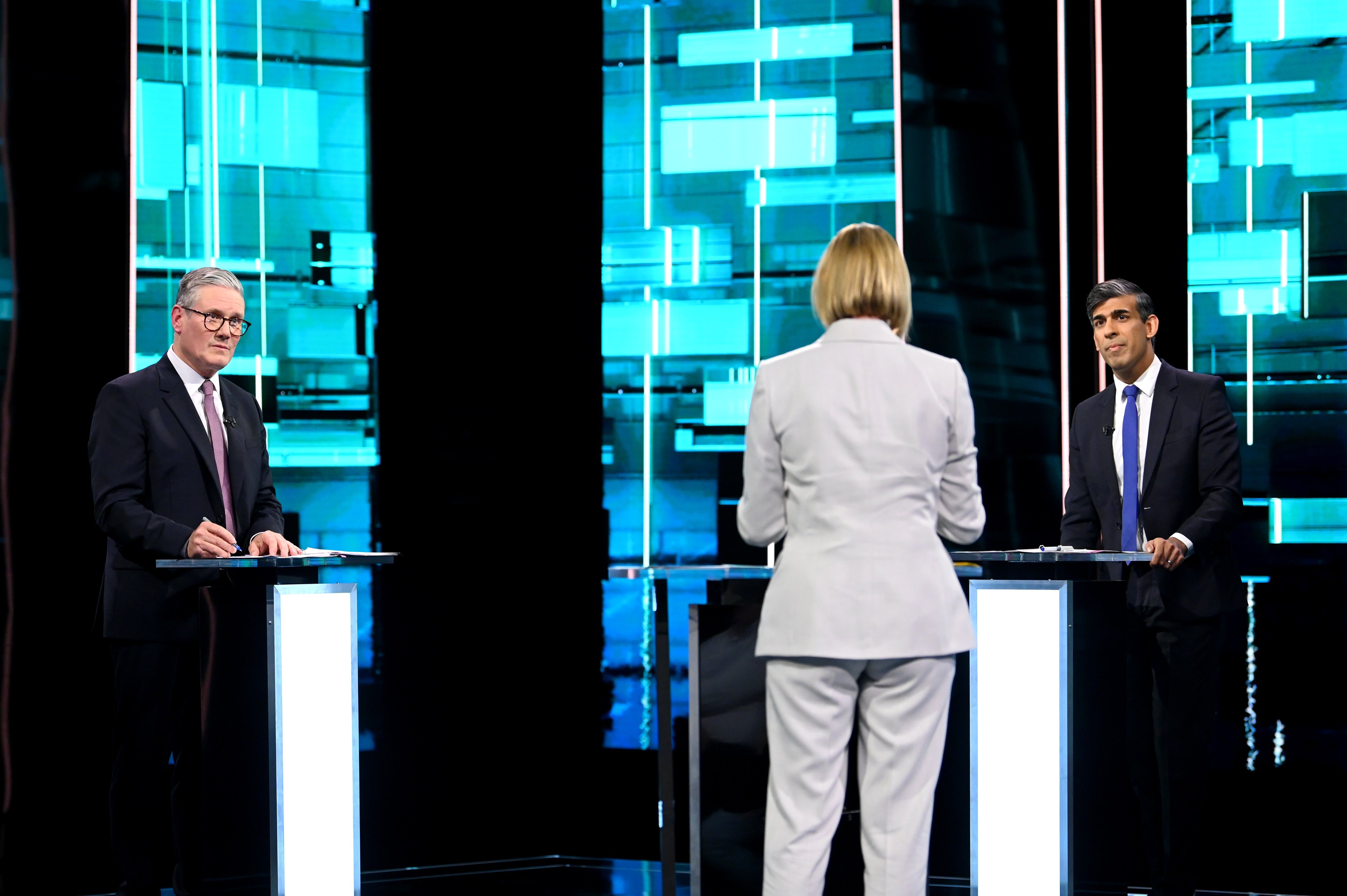 Host Julie Etchingham in the centre of the ITV Debate studio with Sir Keir Starmer and Rishi Sunak stood behind podiums