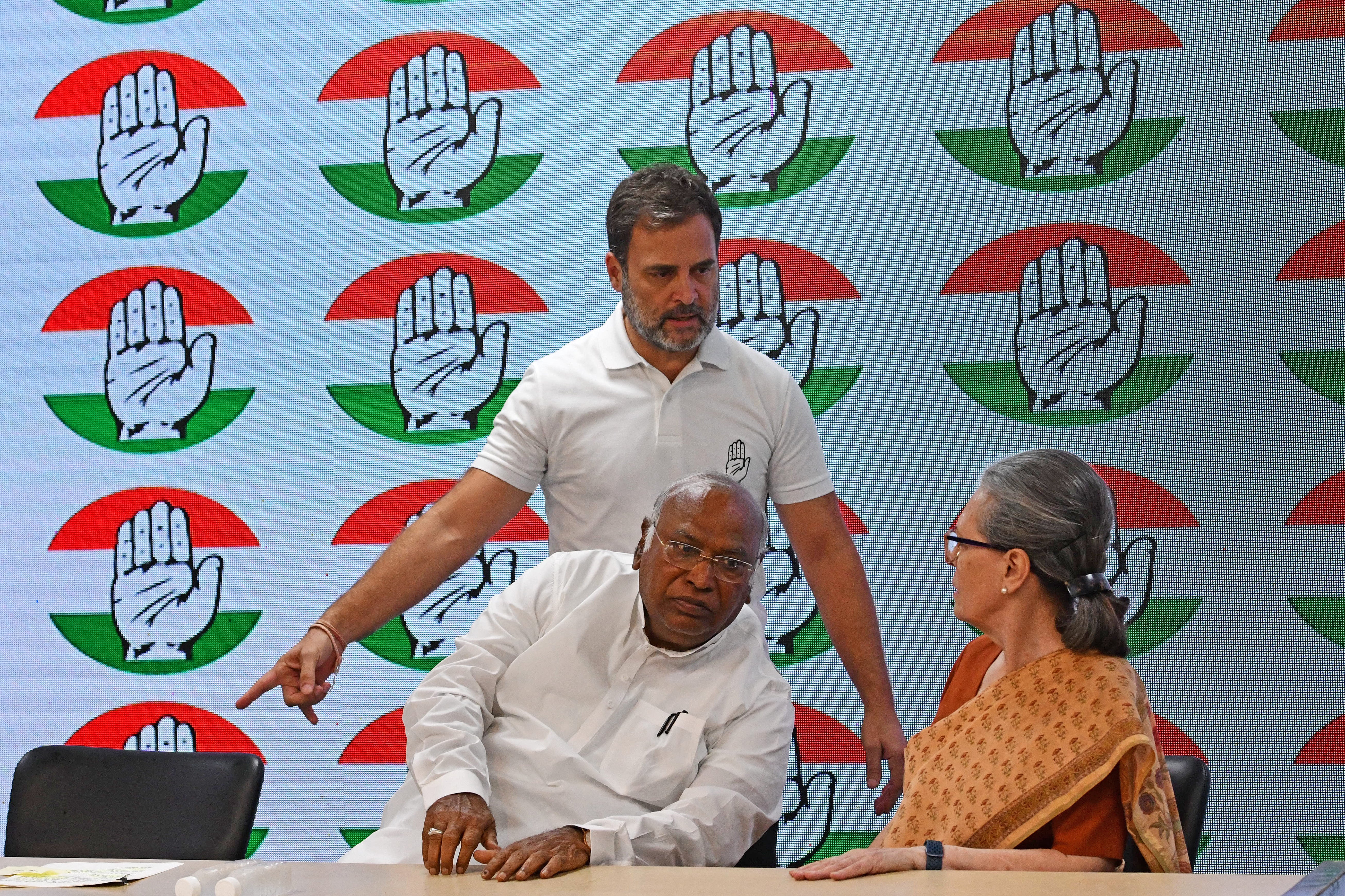 Rahul Gandhi gestures to his mother Sonia Gandhi as party president Mallikarjun Kharge watches before addressing a press conference