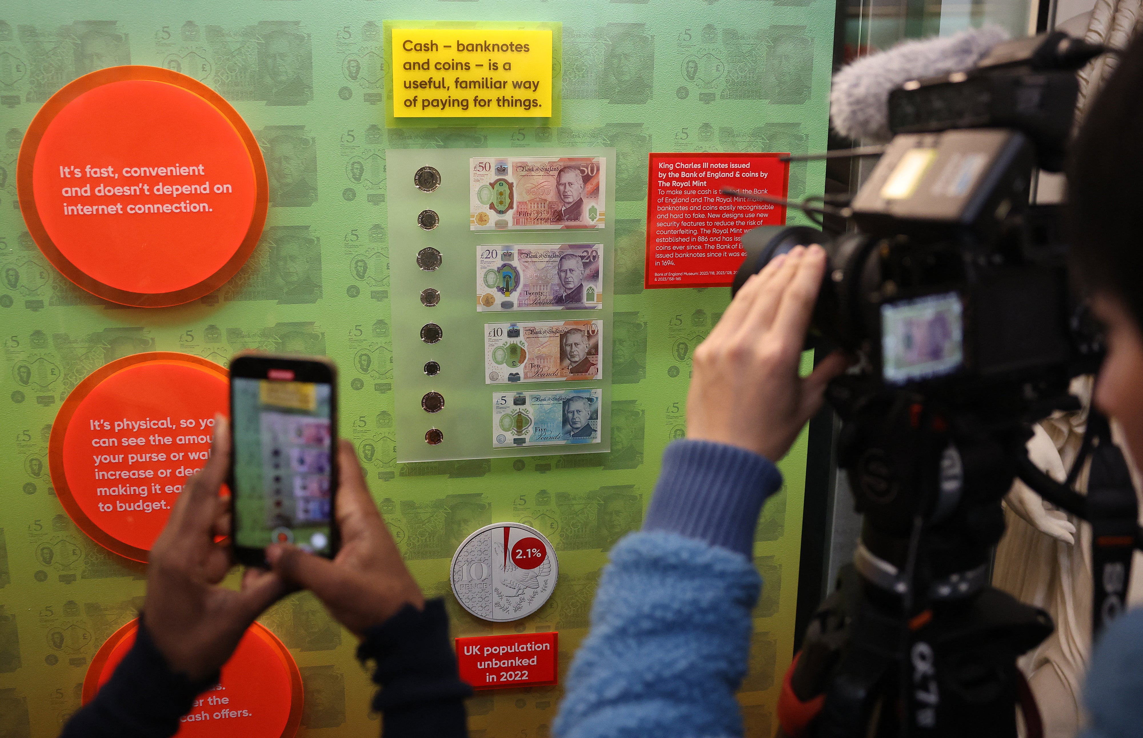 Members of the media film and photograph bank notes and coins that feature an image of Britain’s King Charles III