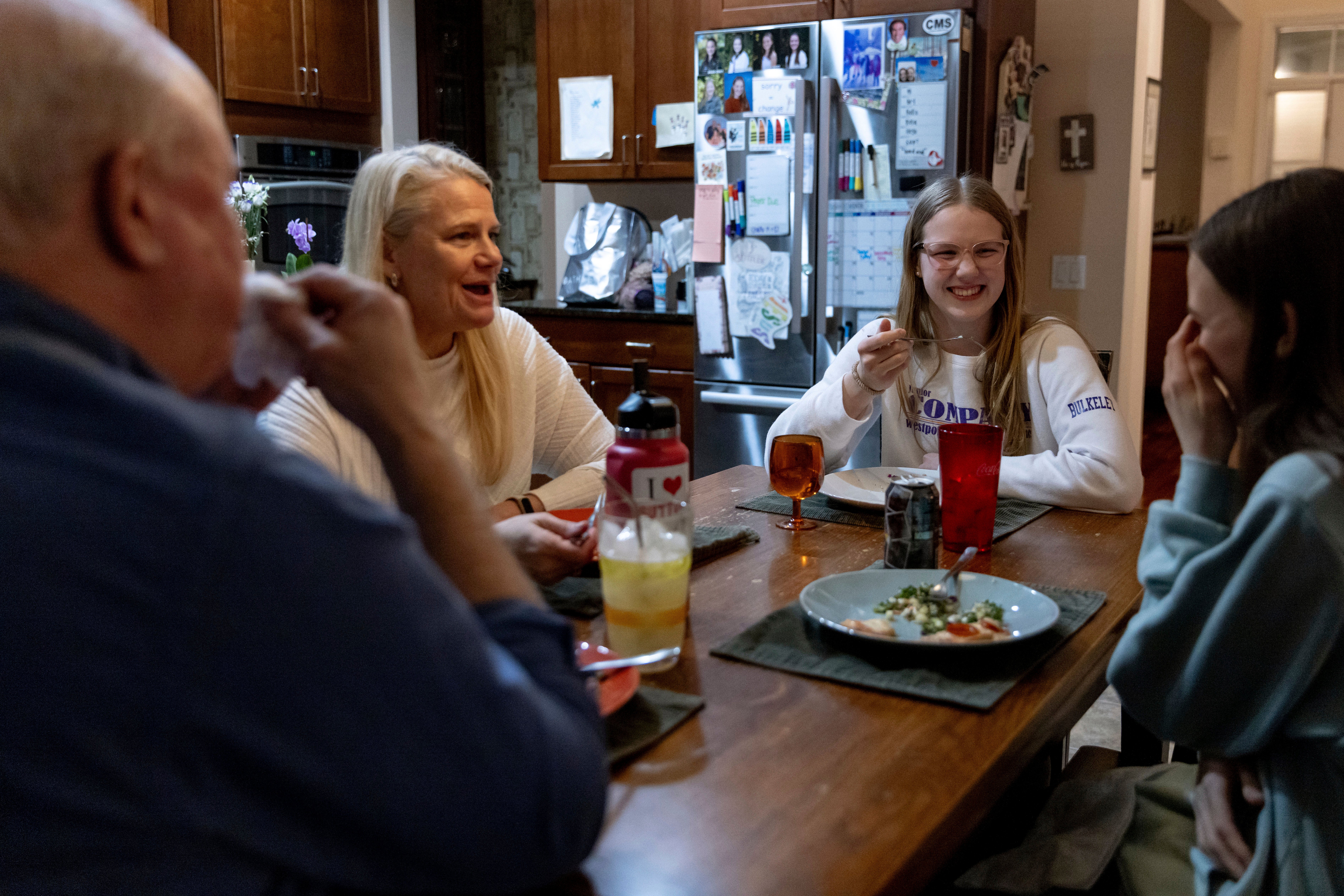 Kate Bulkeley, second from right, eats dinner with her family, Friday, Feb. 16, 2024