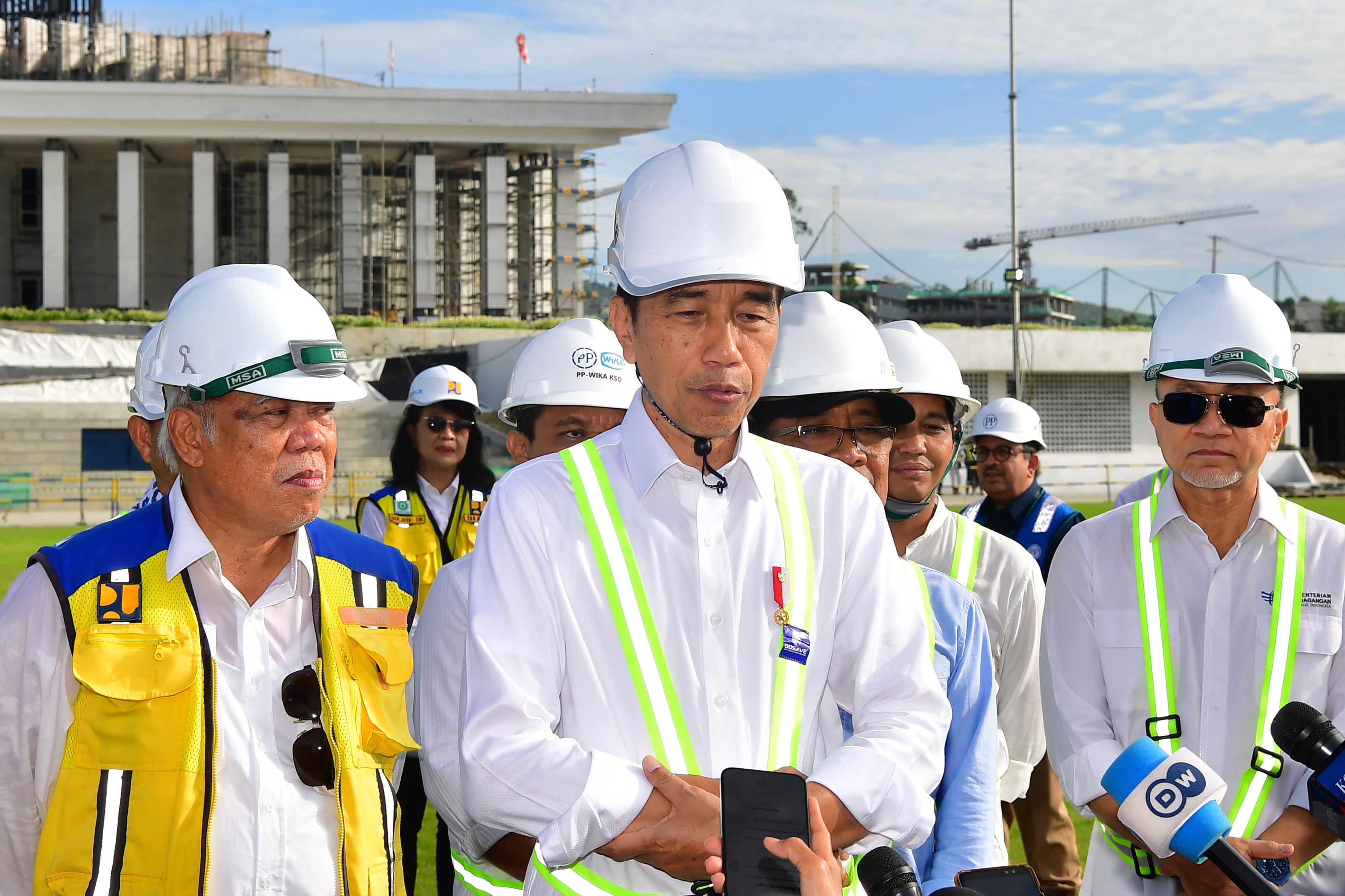 In this photo released by Indonesian Presidential Palace, Indonesian President Joko Widodo, center, talks to journalists after he inspected the presidential palace construction site at the new capital city Nusantara in Penajam Paser Utara, East Kalimantan, Indonesia, Wednesday, June 5, 2024