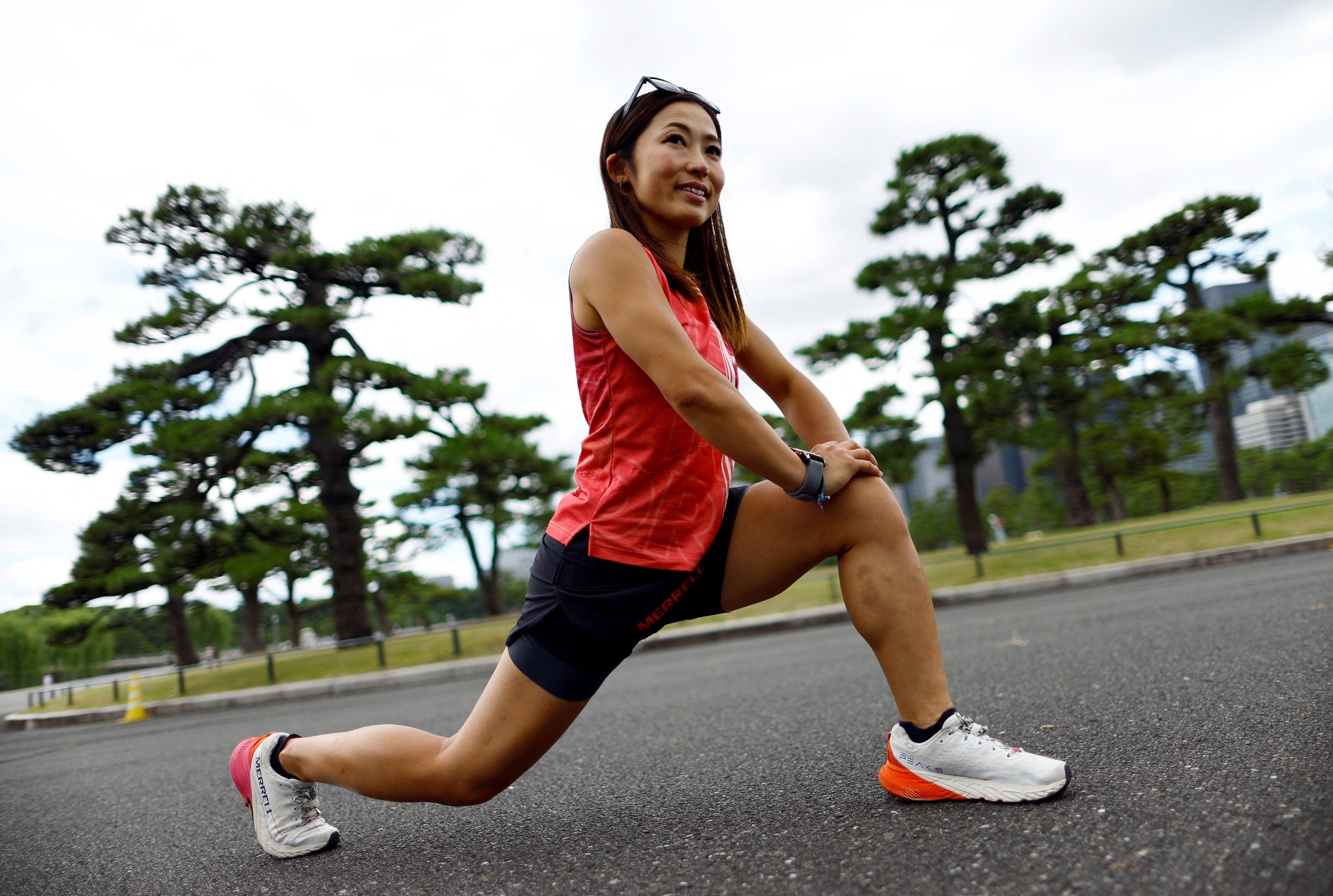 Tomomi Bitoh, 33, Japan’s top ultra runner, stretches as she takes part in a workout session around the Imperial Palace in Tokyo, Japan June 4, 2024