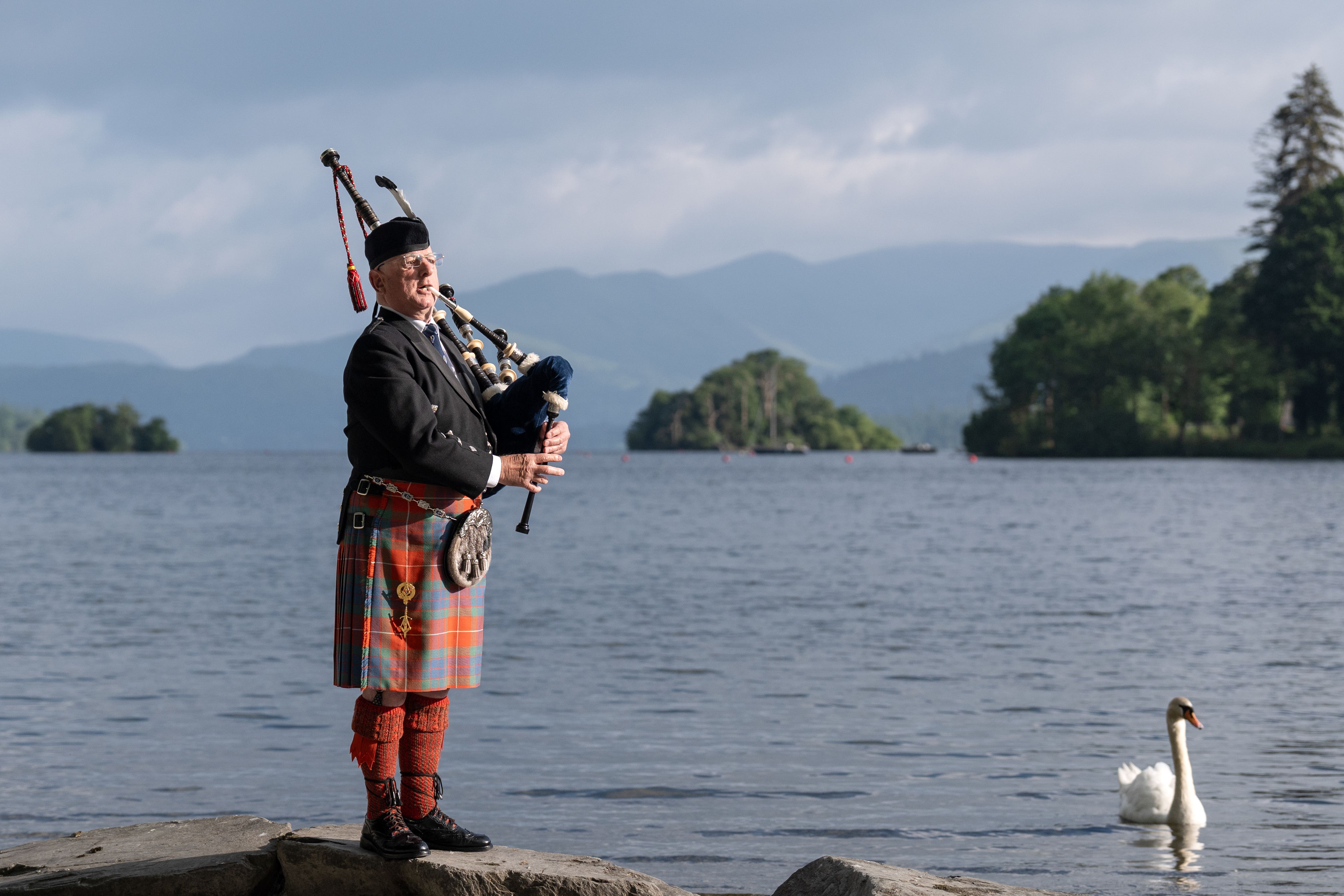 Lone bagpiper Richard Cowie, from the Cumbria Freemasons, warms up his pipes ahead of playing on the deck of one of Windermere Lake Cruises traditional steamers at Bowness-on-Windermere, Lake District, during a D-Day commemoration event (Danny Lawson/PA)