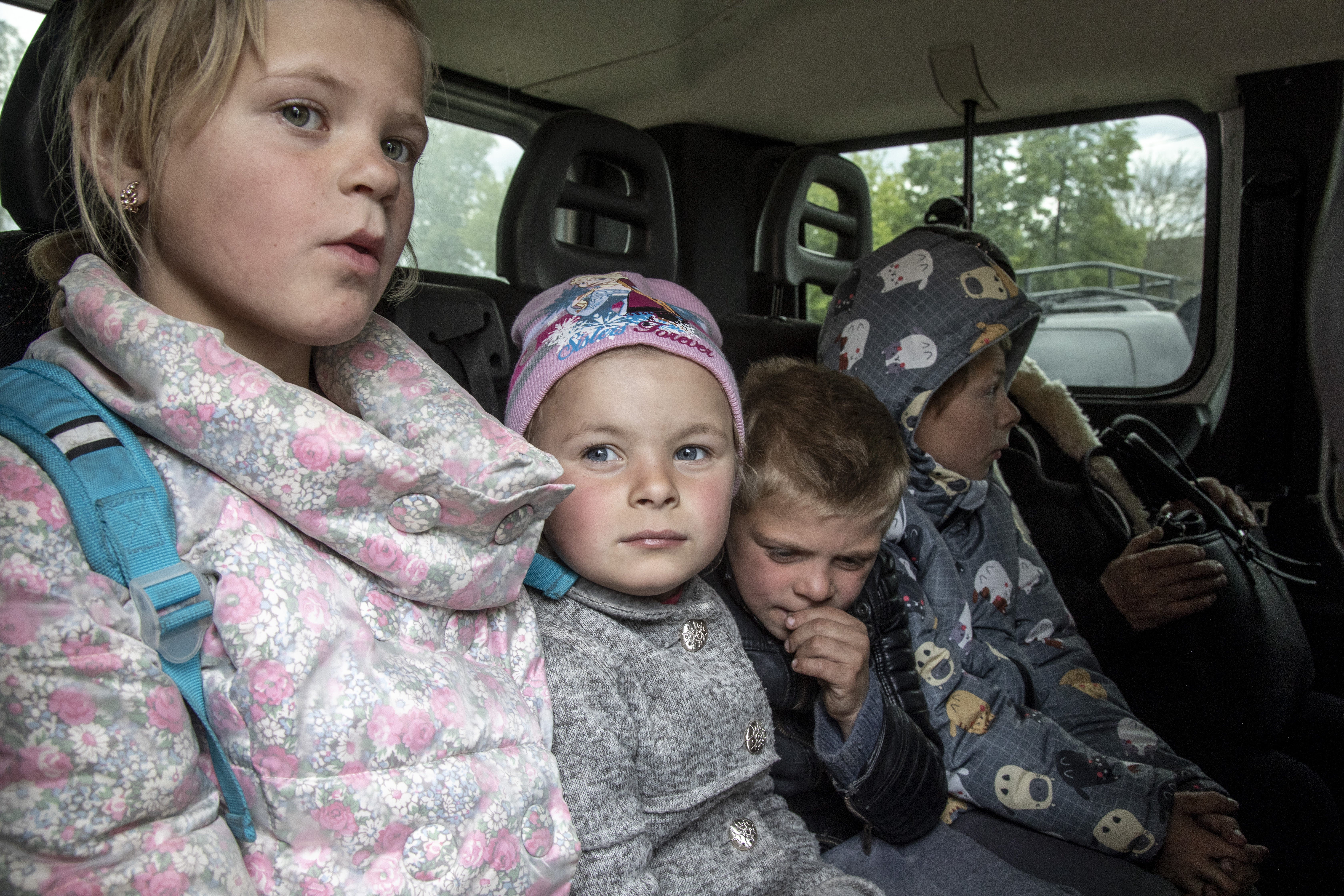 Four of Valentyna’s children - Tetiana, 10, Angelina, 6, Iaroslav, 8, and Sasha, 9 - are pictured in the back of a minibus as they drive towards Kharkiv from the hometown of Zakharivka