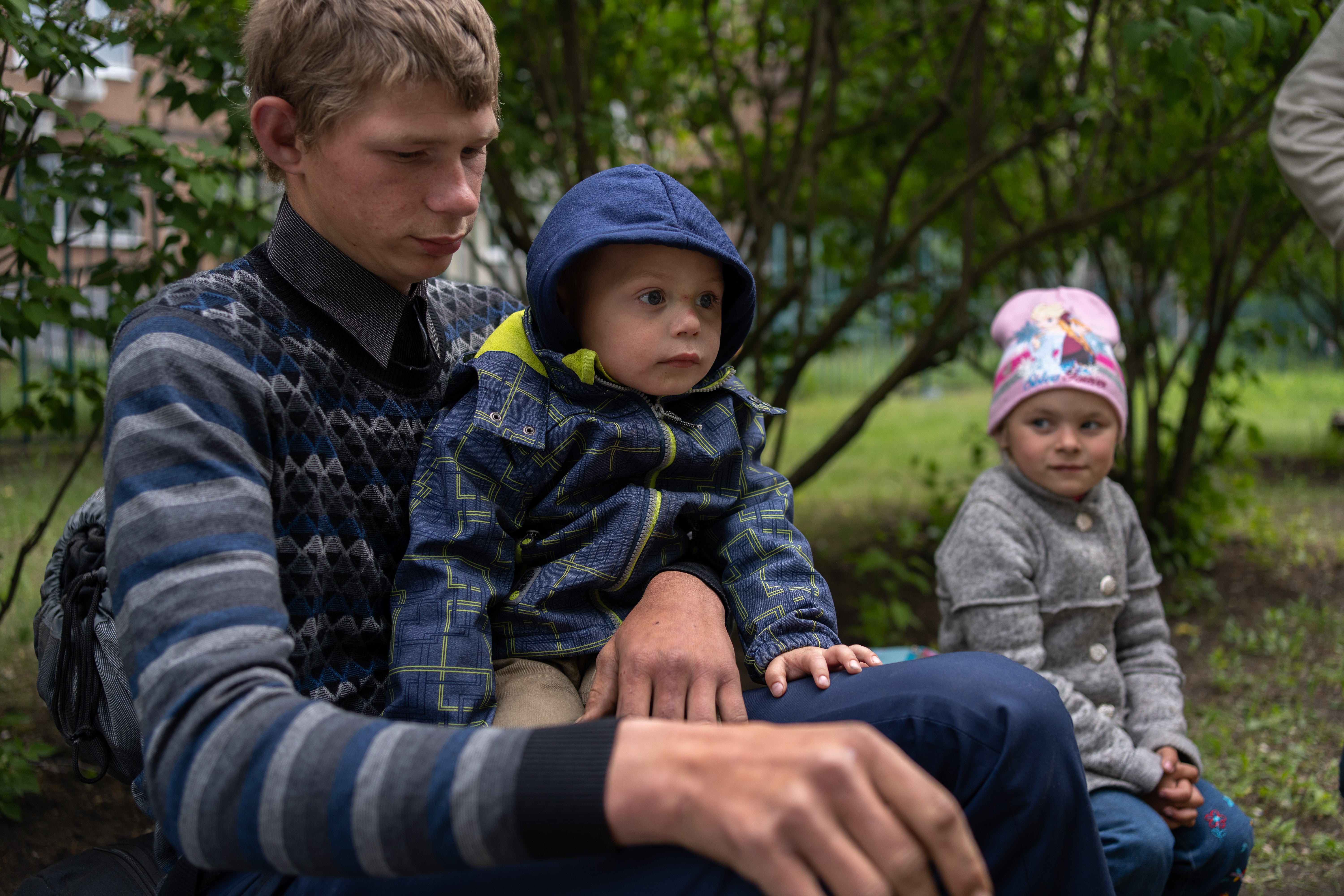 Matviy on the lap of his oldest brother Mykyta after they arrive in Kharkiv. Angelina is next to them