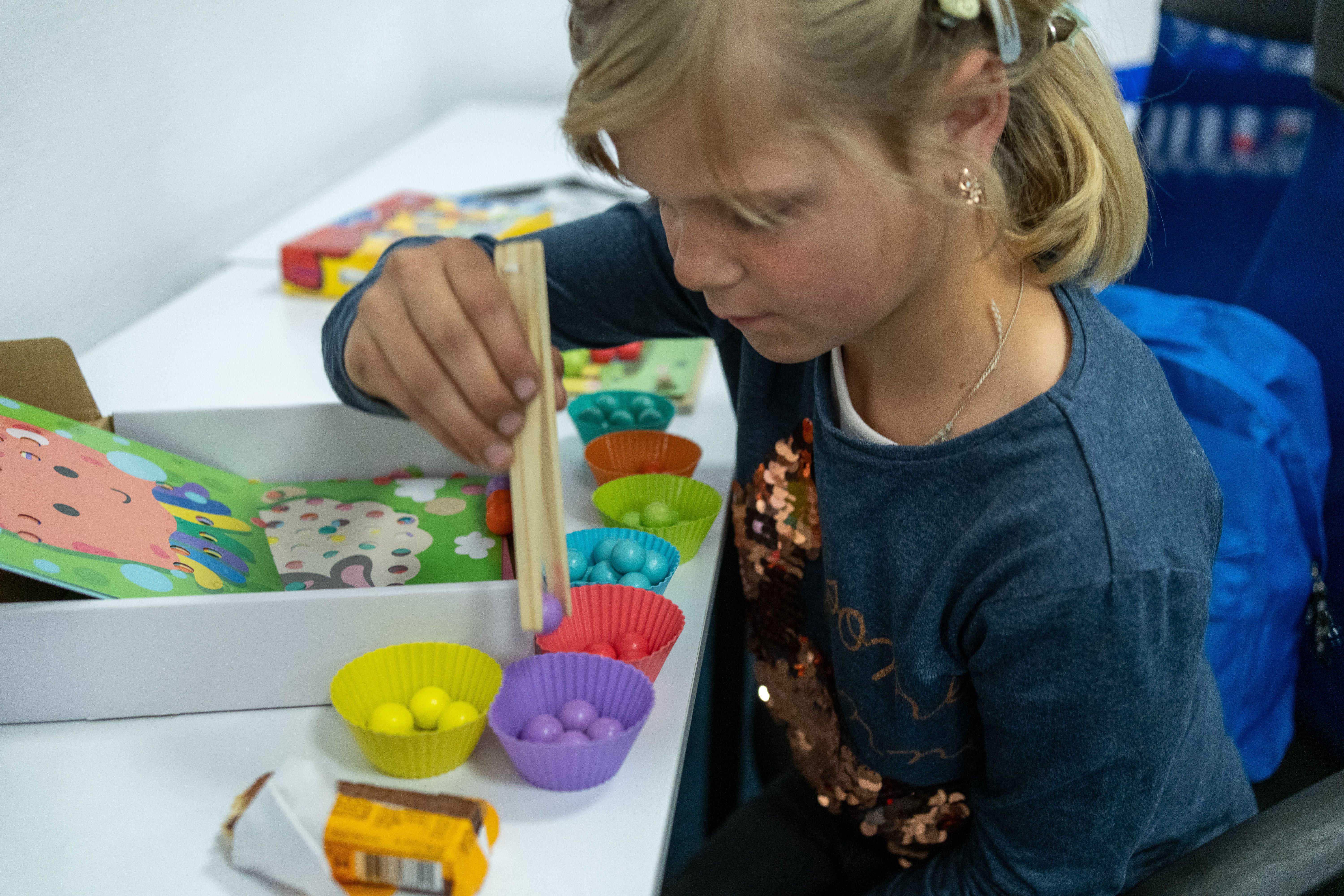 Tetiana plays with coloured pebble balls in the centre