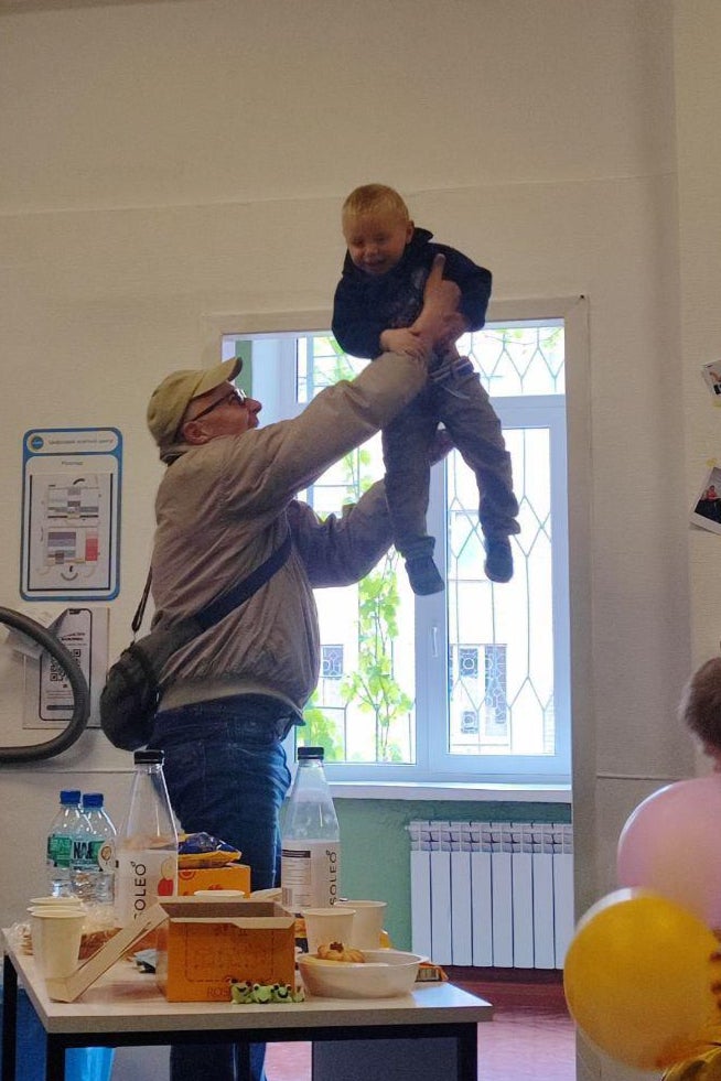 A Rescue driver throws Matviy in the air, the toddler laughing in delight