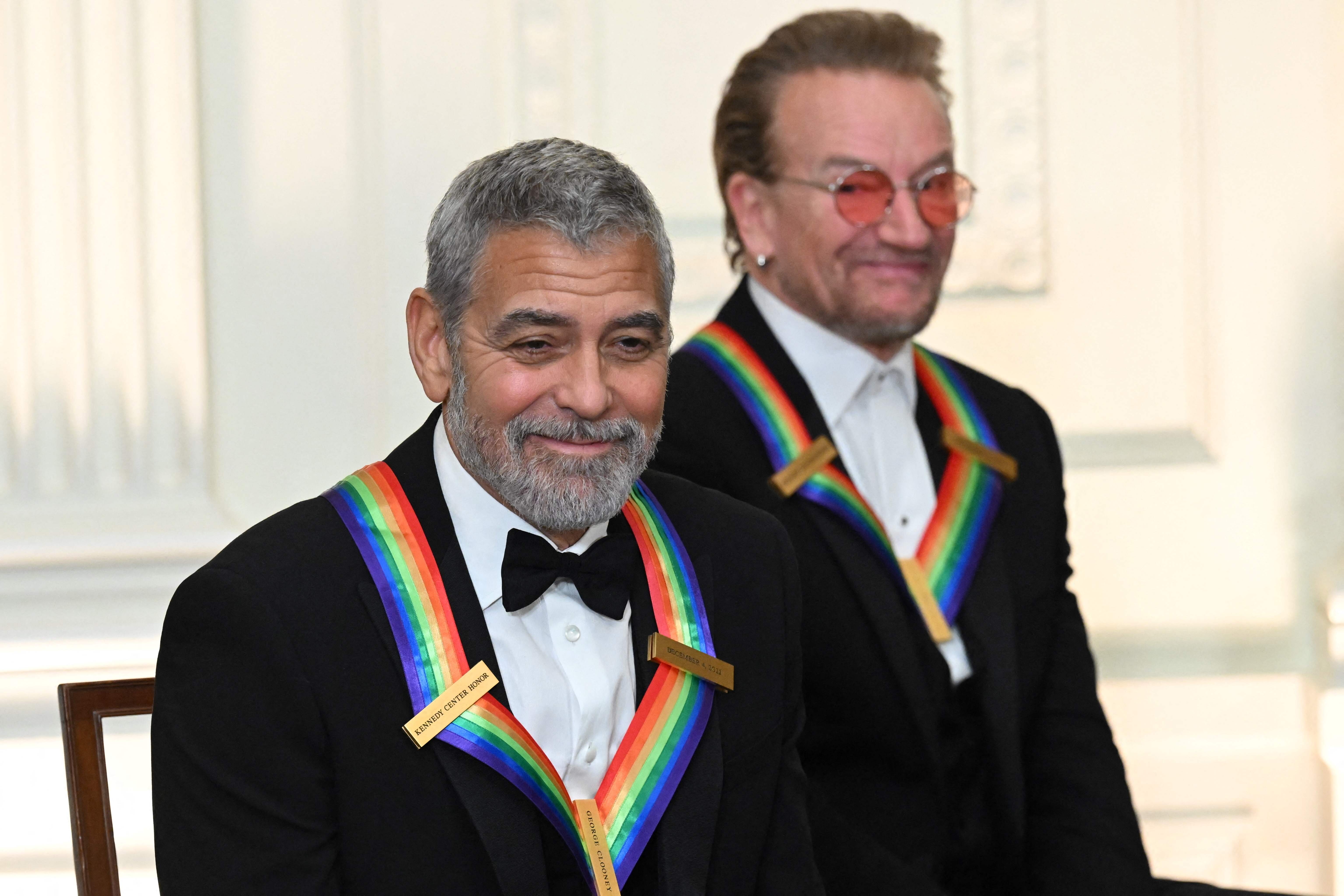 Kennedy Center honorees US actor George Clooney (L) and Bono of Irish band U2 attend a reception for the Kennedy Center Honorees in the East Room of the White House in Washington, DC, on December 4, 2022