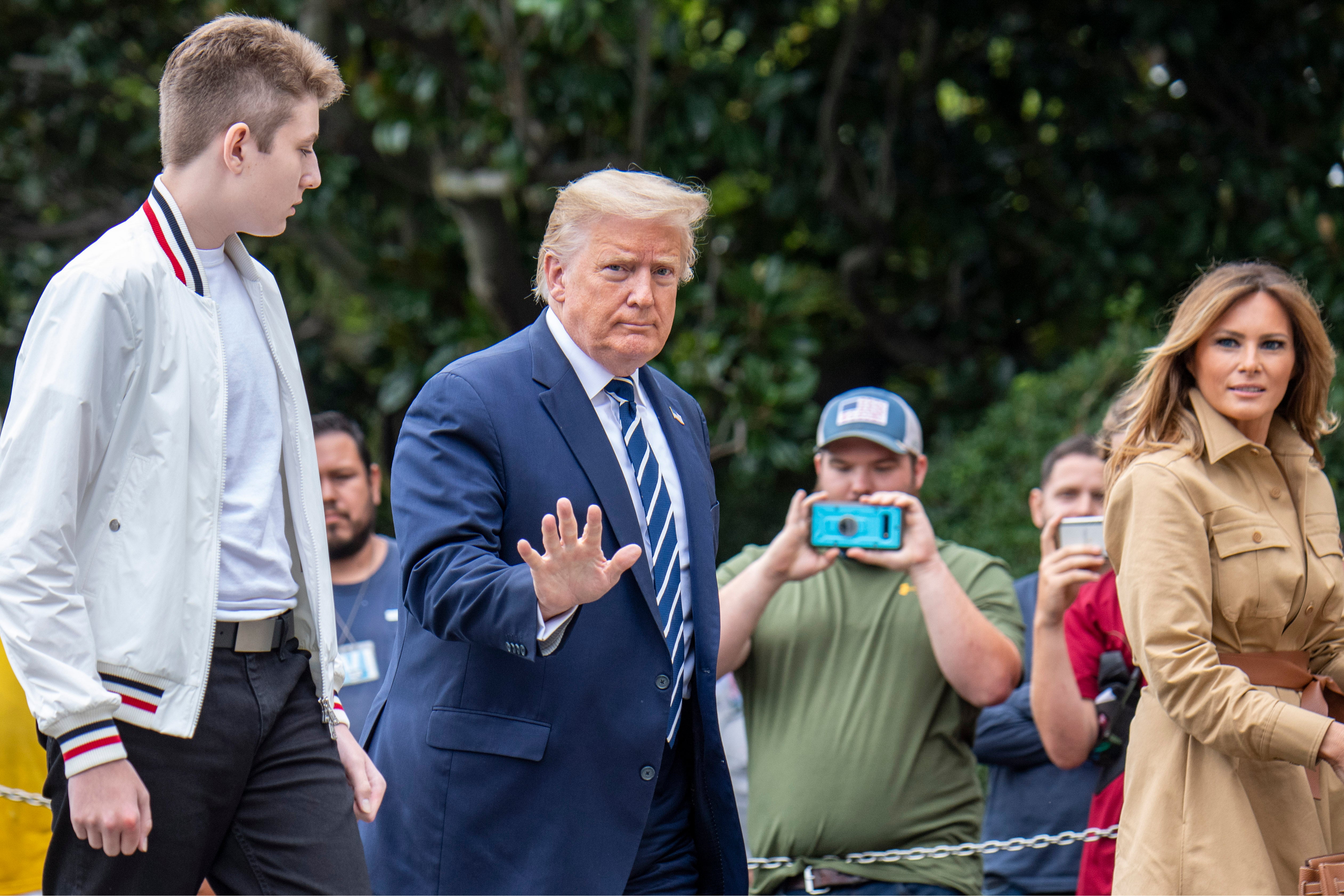 US President Donald Trump returns to the White House with First Lady Melania Trump (R) and their son Baron (L) after a weekend in Bedminster on August 16, 2020 in Washington, DC