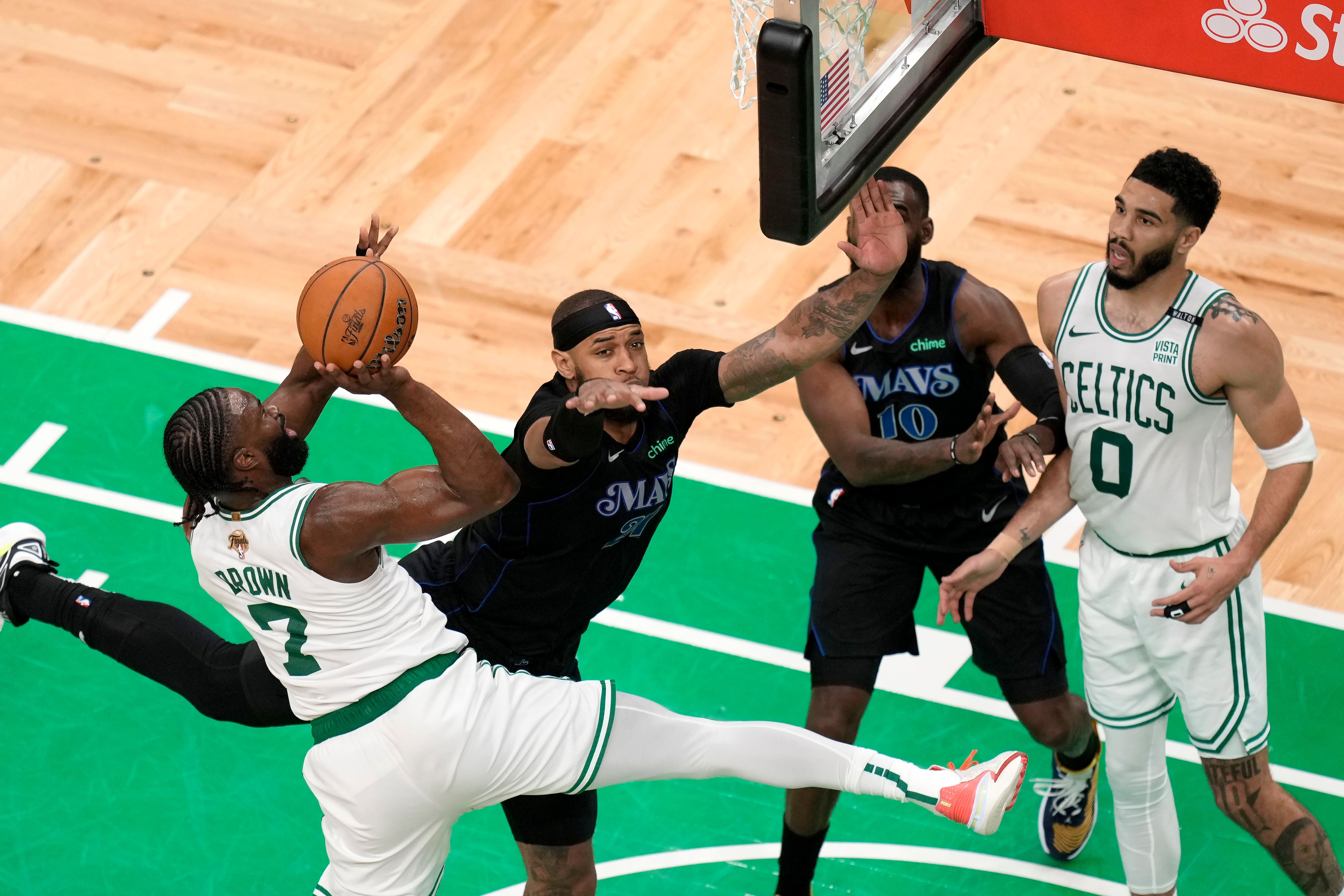 Jaylen Brown (left) shoots as Dallas Mavericks centre Daniel Gafford, (centre left), defends in front of Mavericks forward Tim Hardaway Jr (centre right) and Celtics forward Jayson Tatum in game one of the NBA Finals (Michael Dwyer/AP)