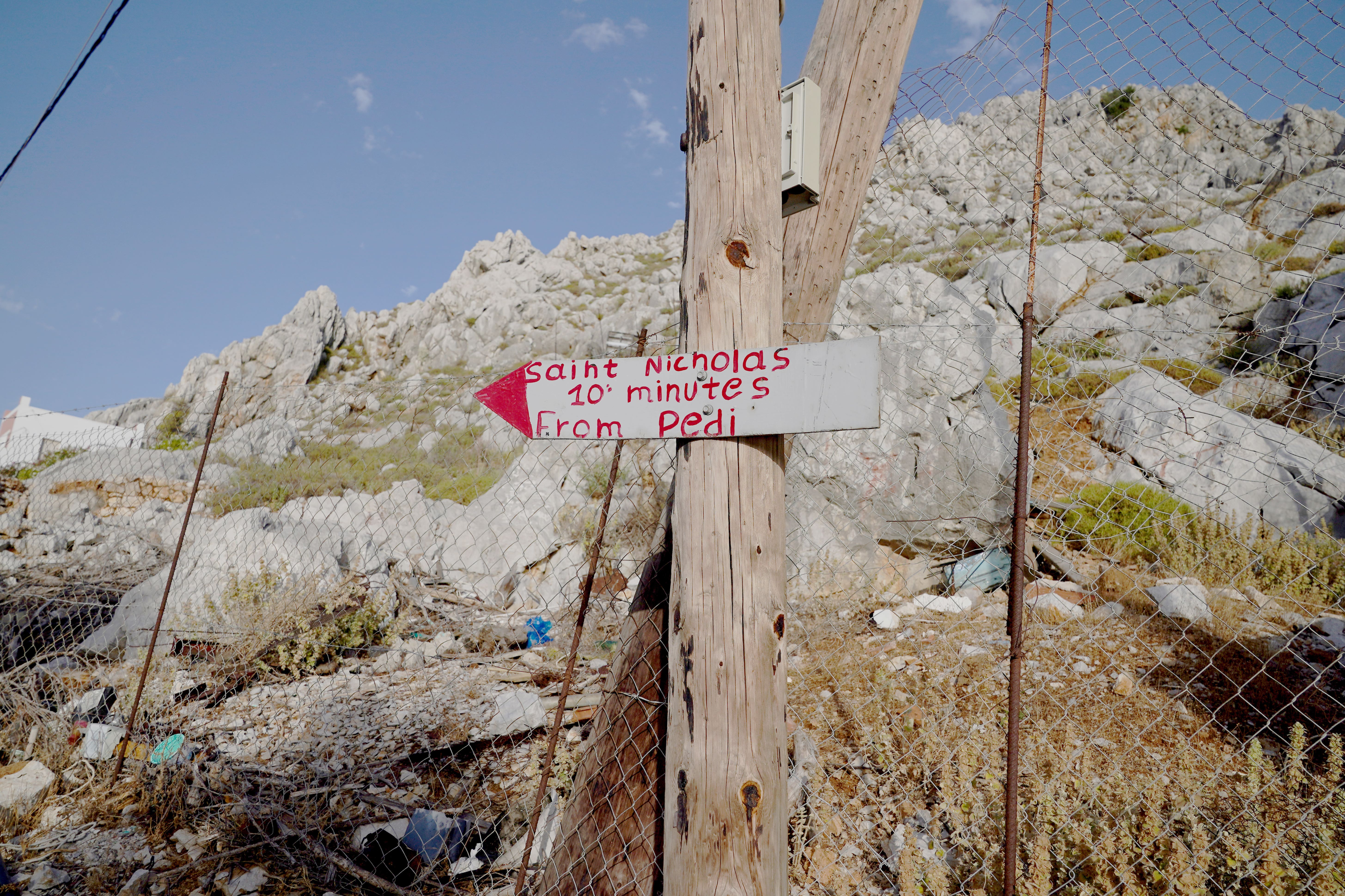 A sign points to Saint Nikolas beach in the Pedi area of Symi, Greece, where a search and rescue operation is under way for TV doctor and columnist Michael Mosley after he went missing while on holiday (Yui Mok/PA)