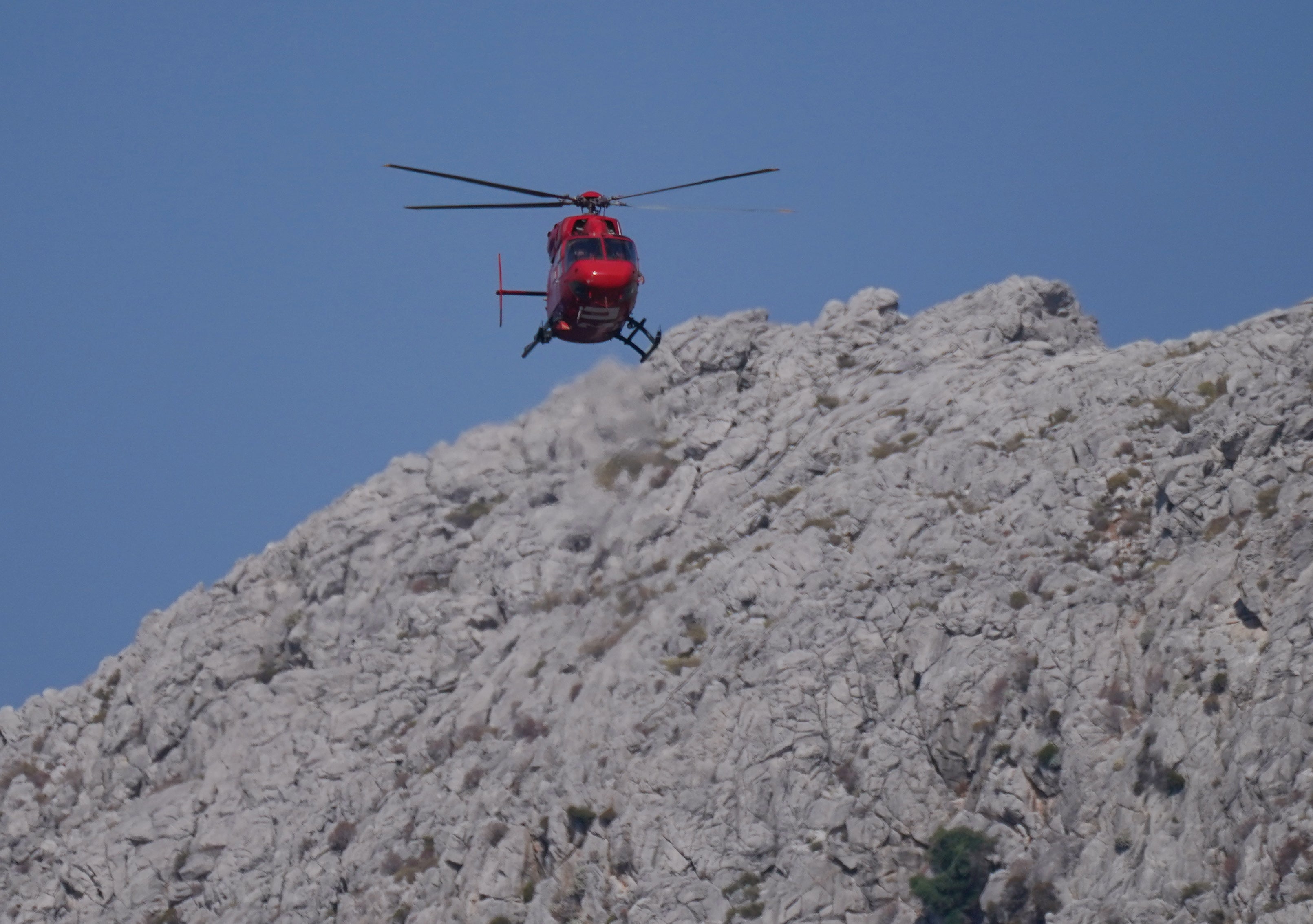 A helicopter flying over the hills in Pedi, Symi, Greece, during the search for Dr Mosley