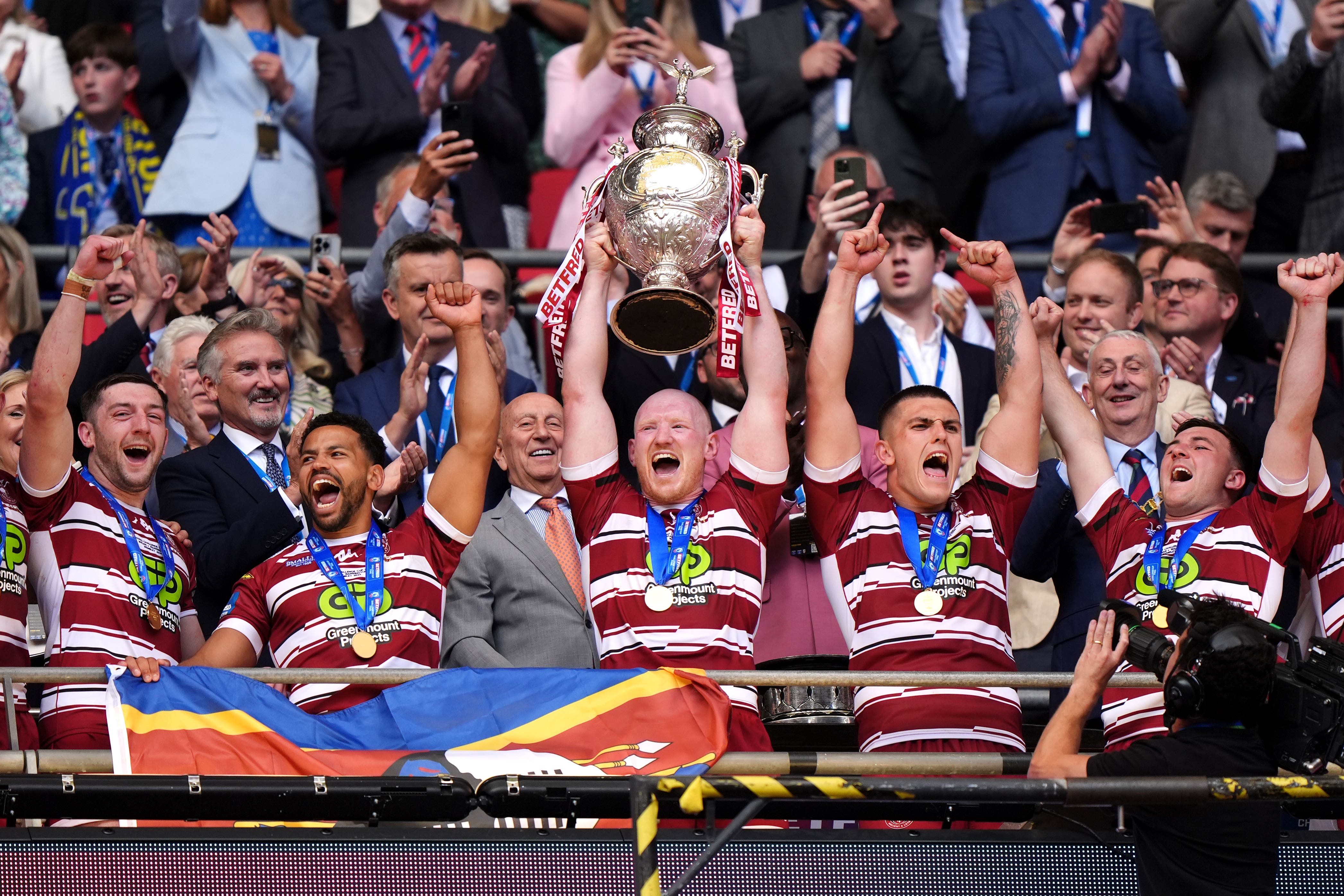 Wigan captain Liam Farrell (centre) lifts the Challenge Cup trophy (John Walton/PA)