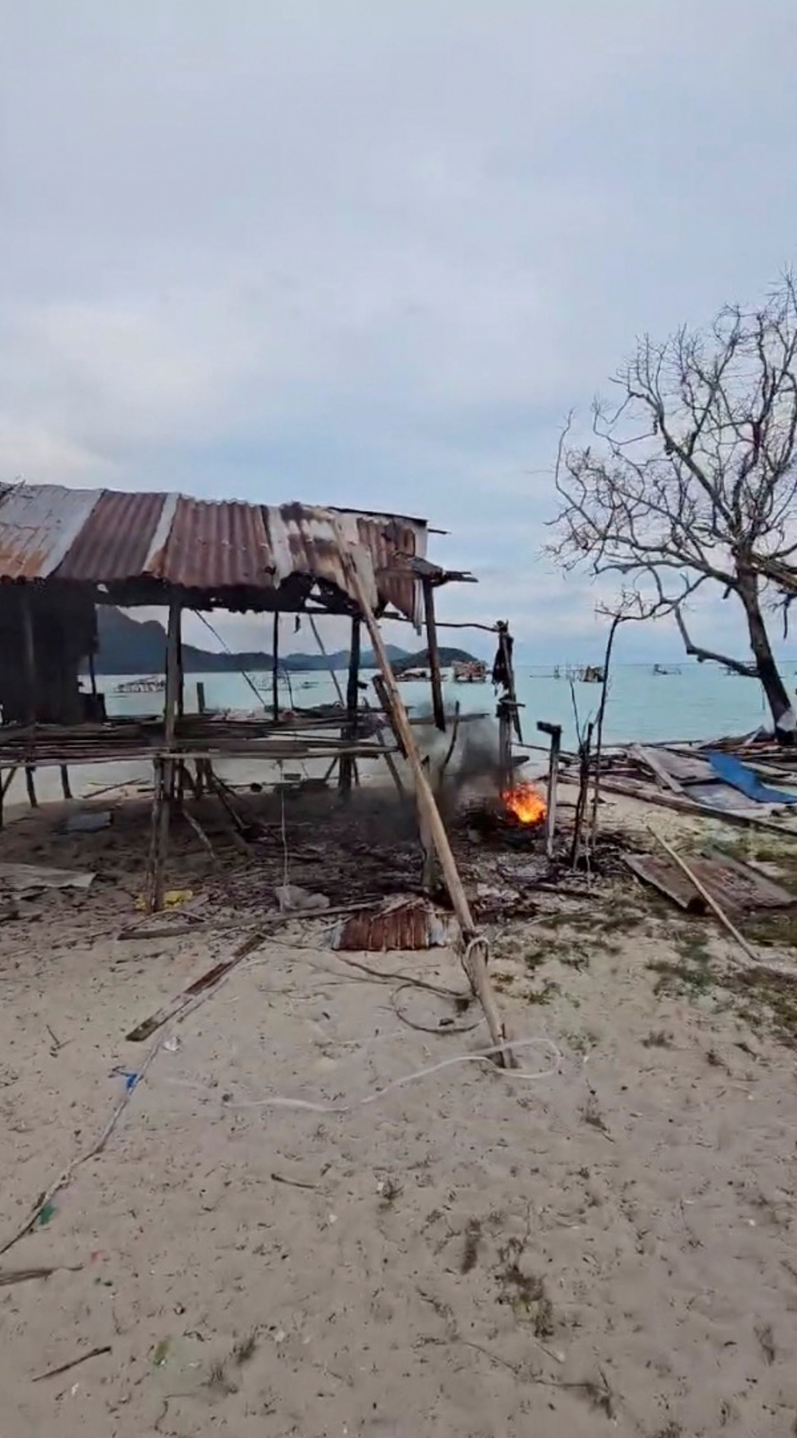 Fire burns next to a house demolished in Tun Sakaran Marine Park, Sabah, Malaysia