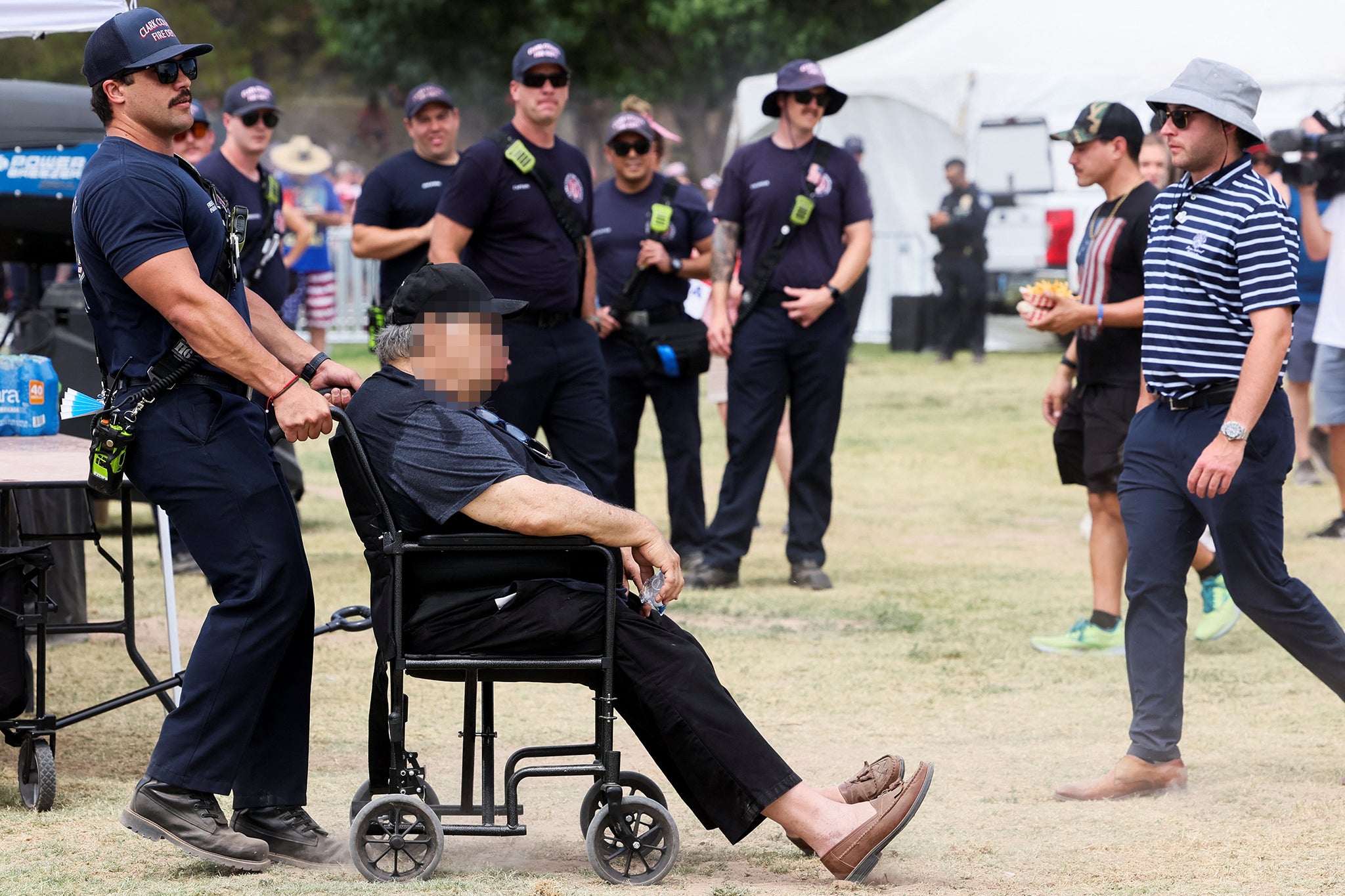 A man suffering from heat exhaustion receives aid from fire department at Trump’s Nevada rally