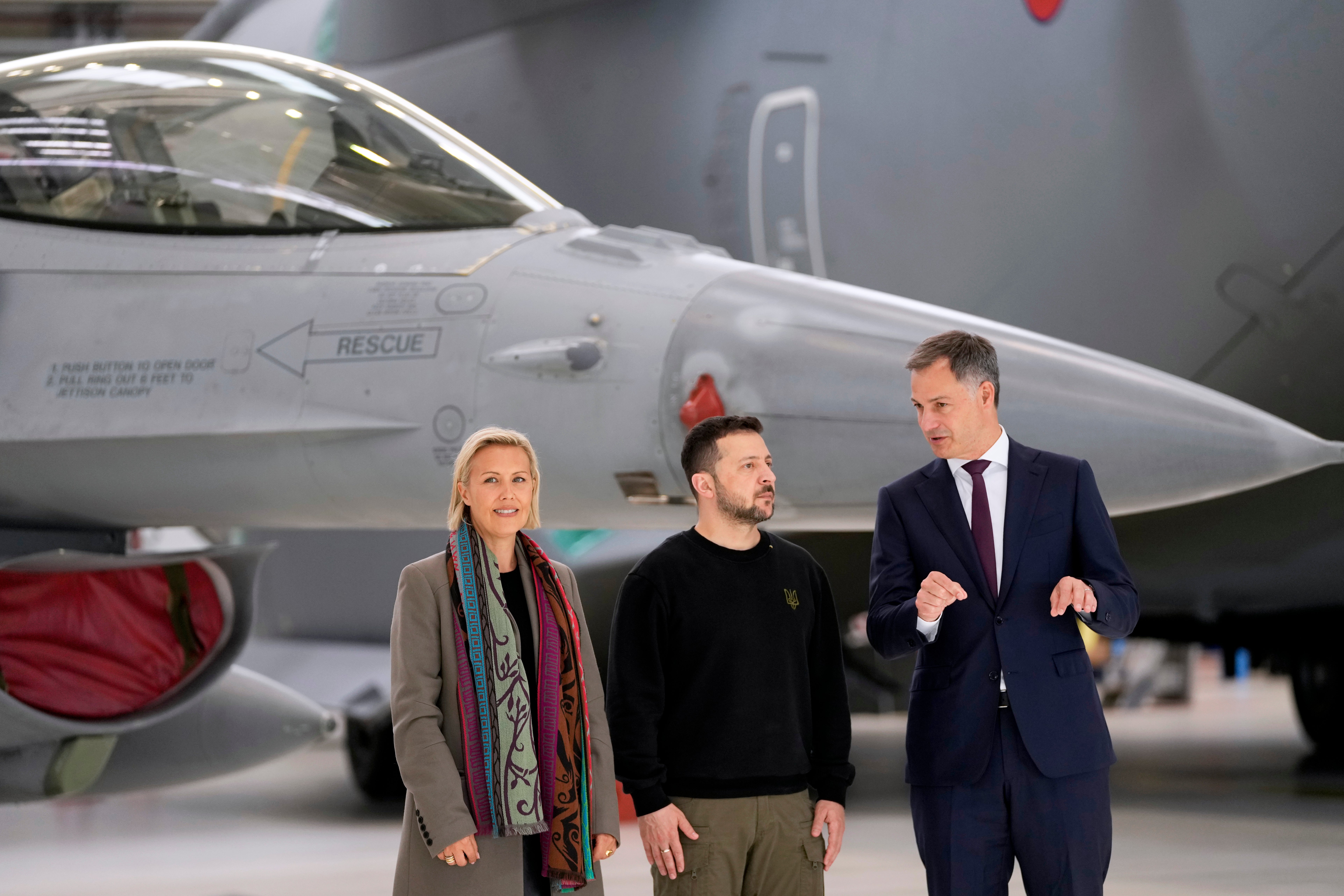 Belgian PM Alexander De Croo, right, and his defence minister Ludivine Dedonder pose with Zelensky in front of an F-16