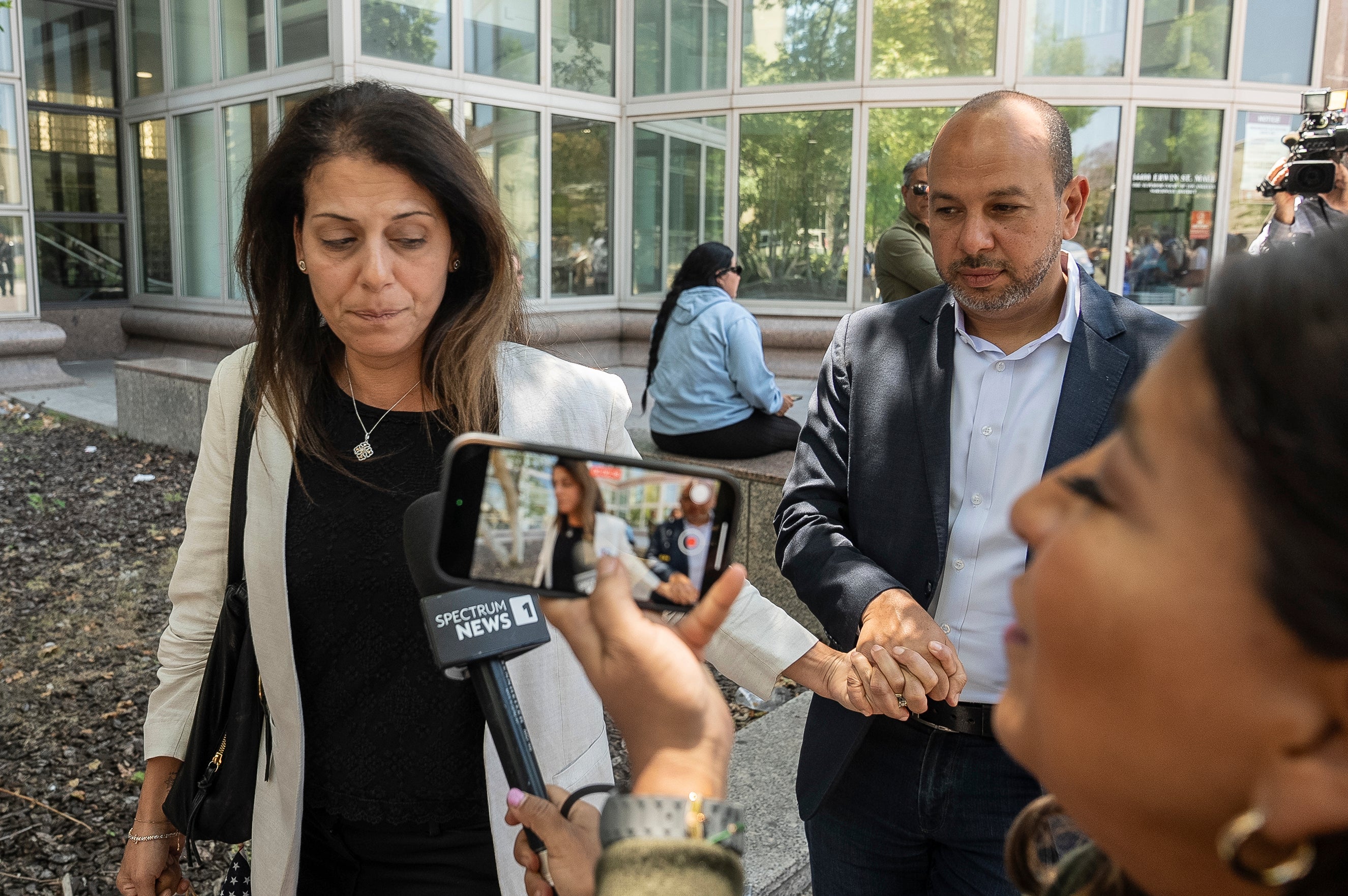 Nancy Iskander, left, holding the hand of her husband, Karim, leaves Van Nuys Courthouse on Monday, June 10, 2024, in Van Nuys, Calif.