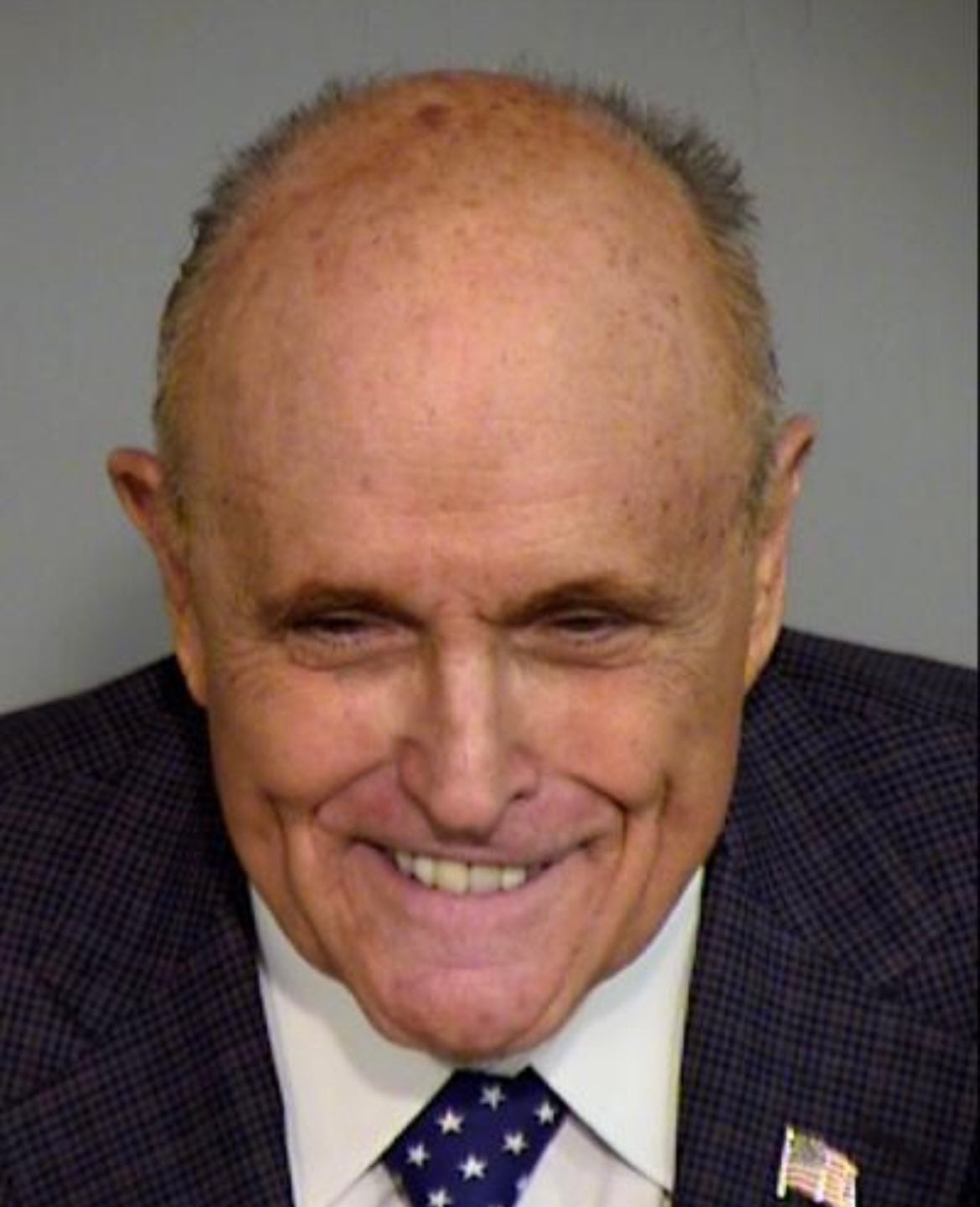 Rudy Giuliani poses for a mugshot weeks after pleading not guilty in an Arizona election interference case