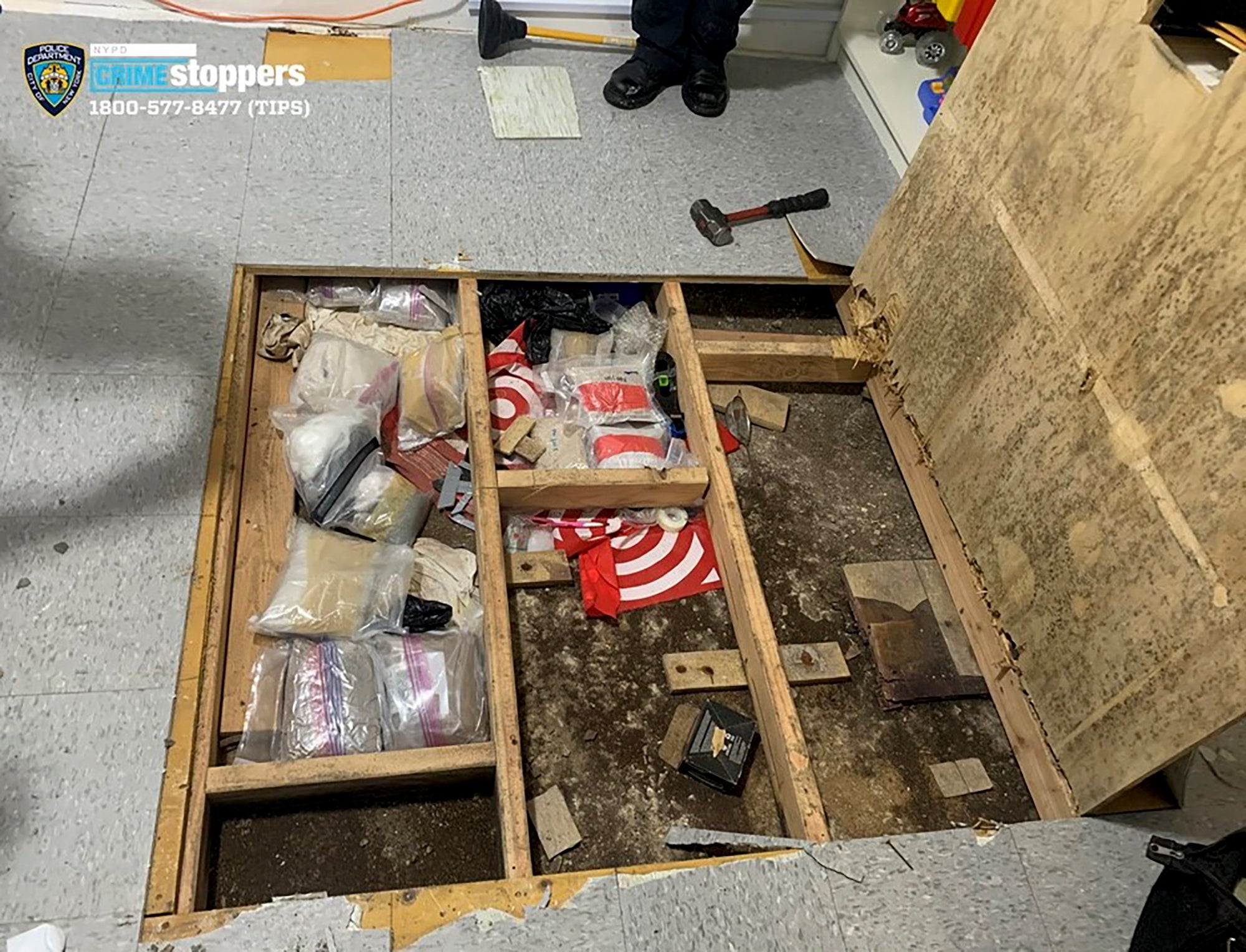 A trap door leans open over narcotics, including fentanyl, and drug paraphernalia stored in the floor of a day care center in September 2023, in New York