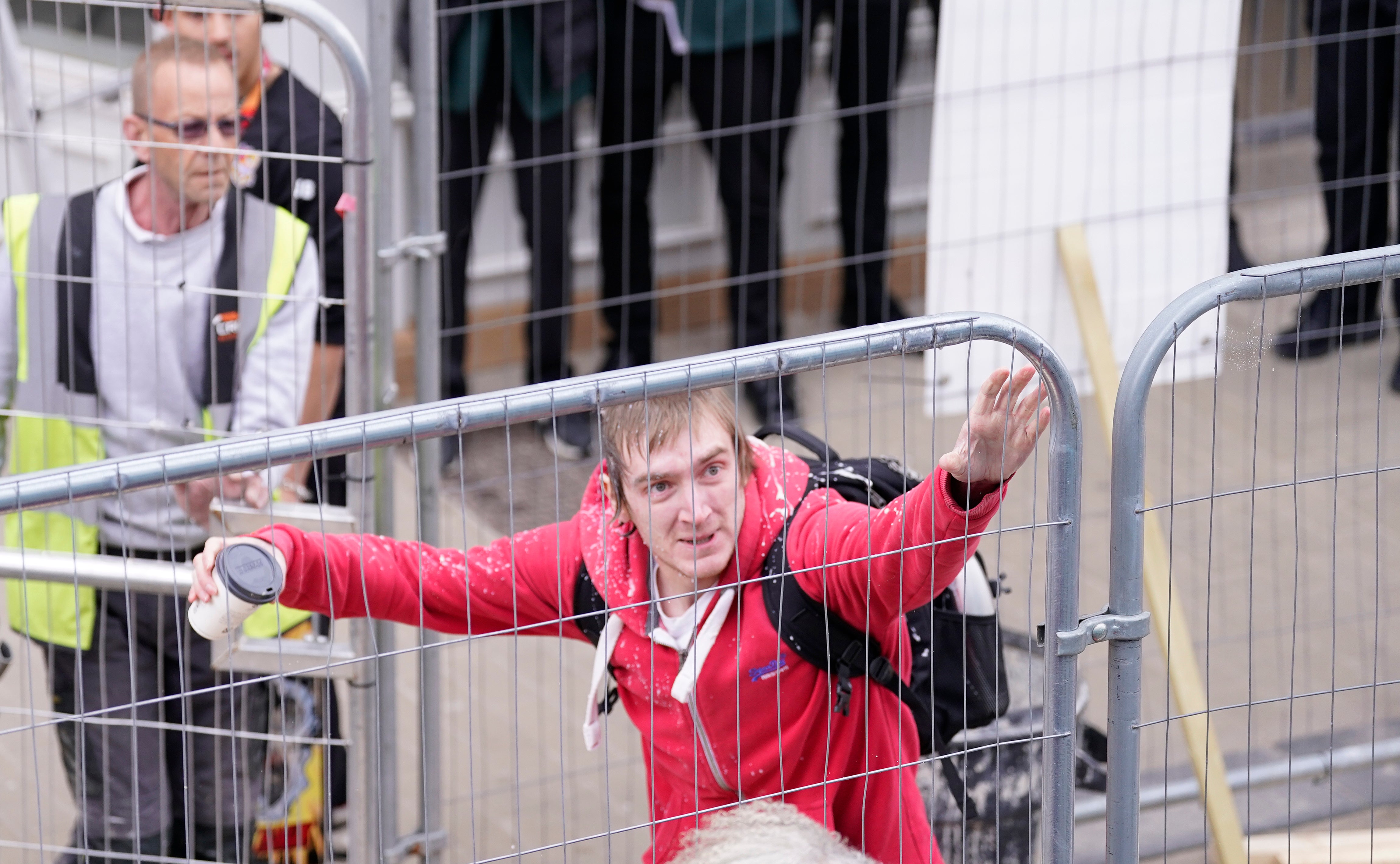 A man in a red jumper was caught on camera hurling the objects