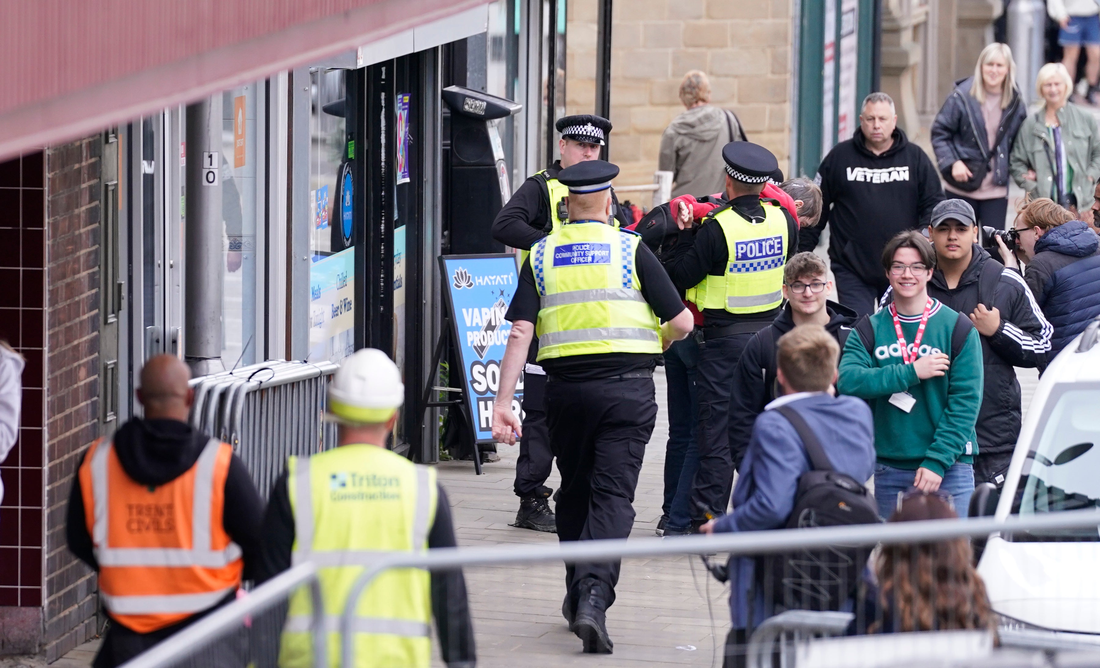 The man could be seen being dragged away by people in green high-vis jackets, then detained by a police officer