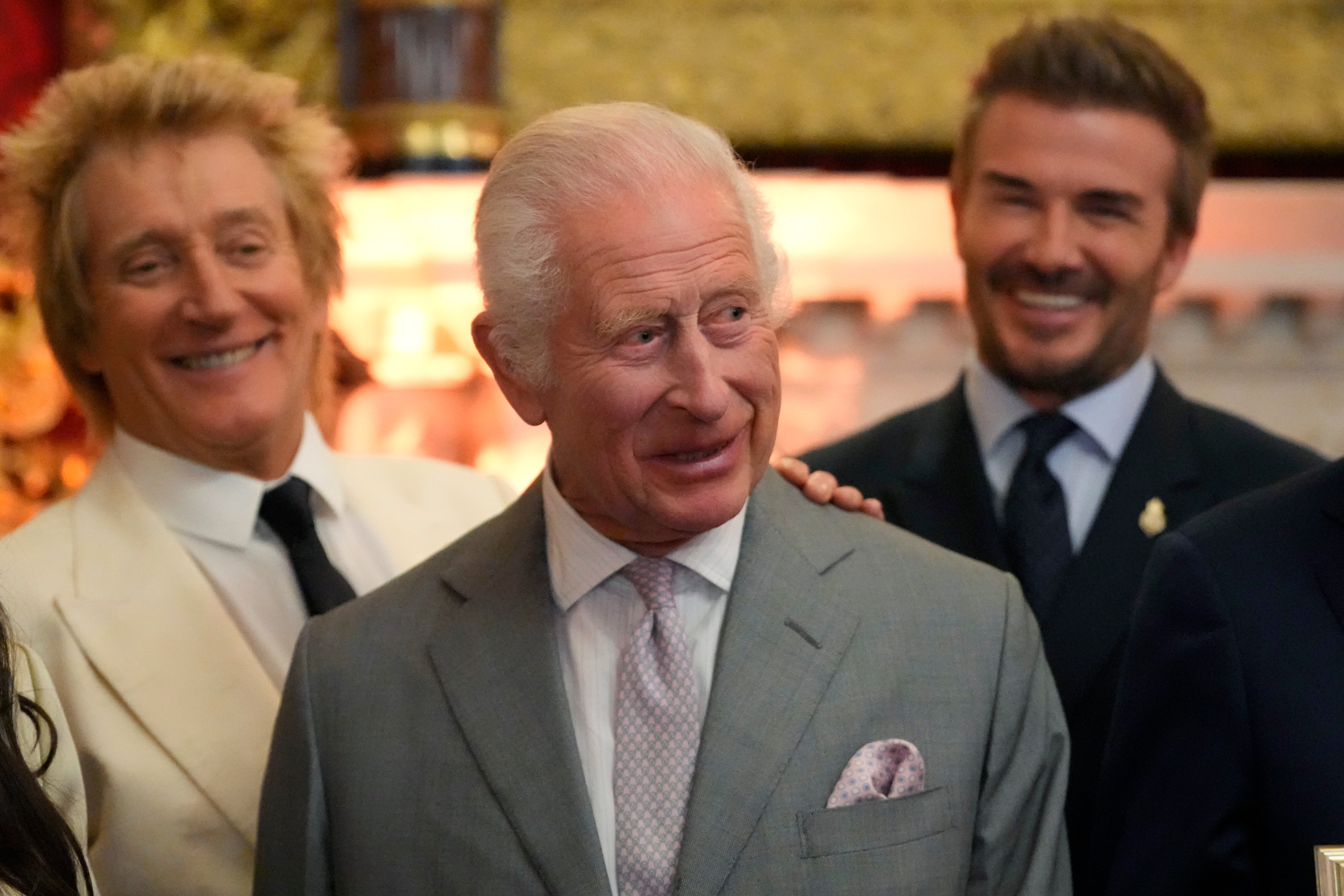 King Charles III smiles as he attends the inaugural King’s Foundation charity awards at St James’s Palace in London with British pop icon Rod Stewart, left, and former footballer David Beckham in the background