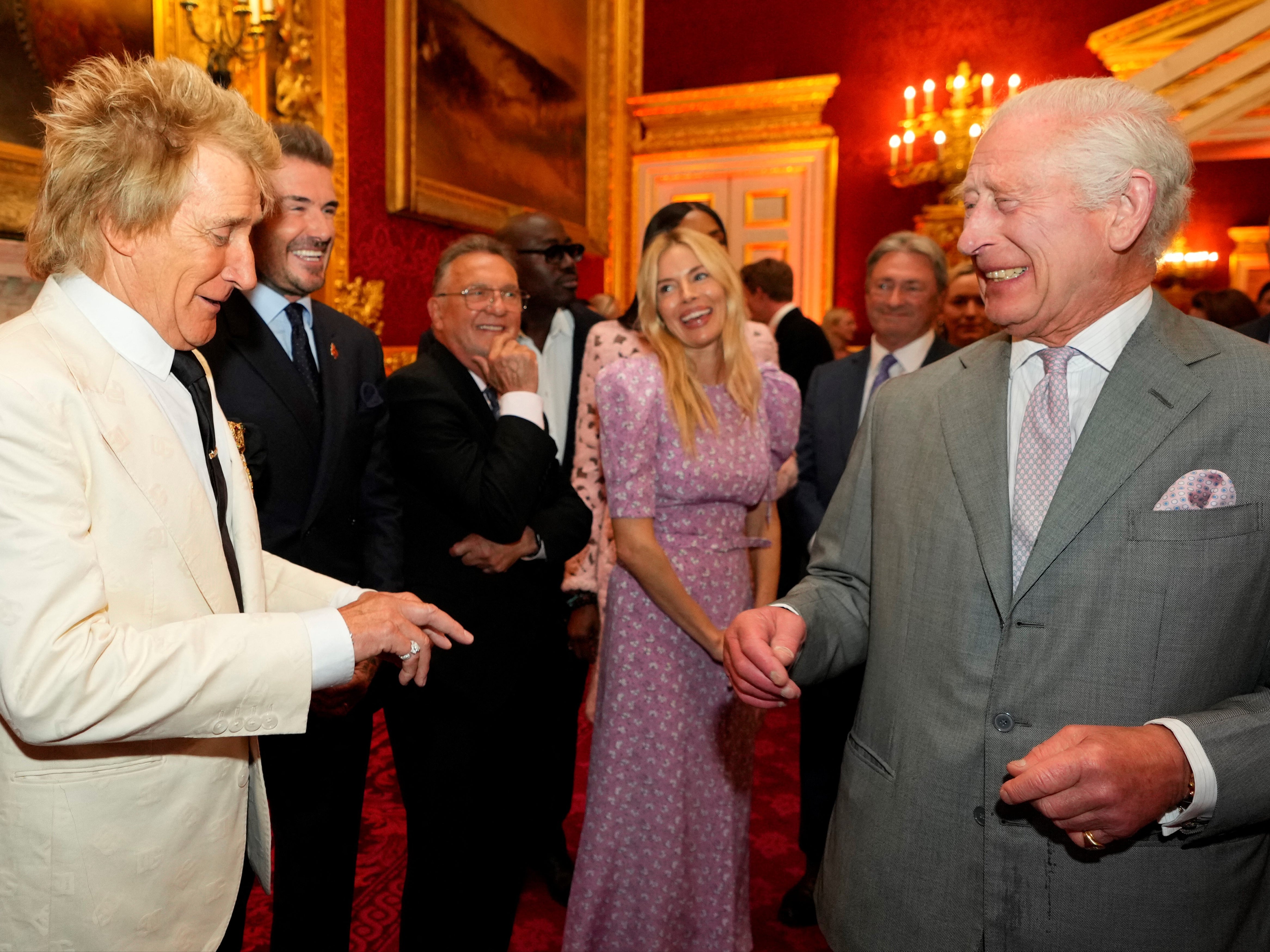 King Charles laughs as he speaks with British singer Rod Stewart, former England player David Beckham and British actor Sienna Miller