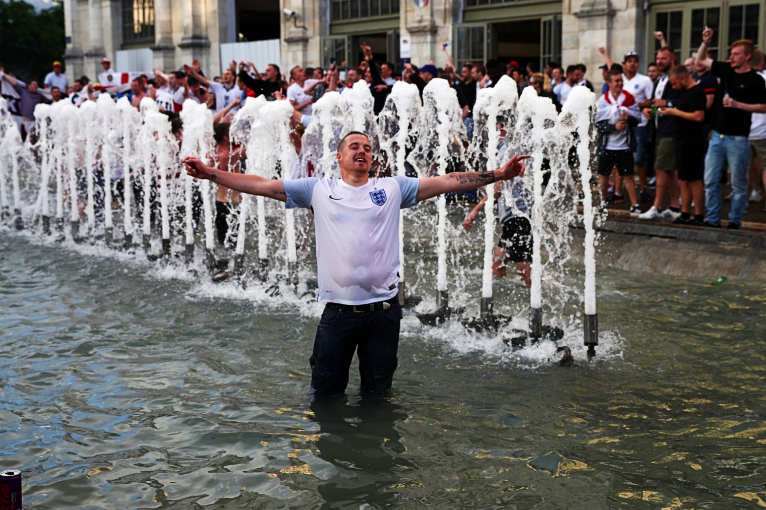 An England fan revels in a water fountain during Euro 2016