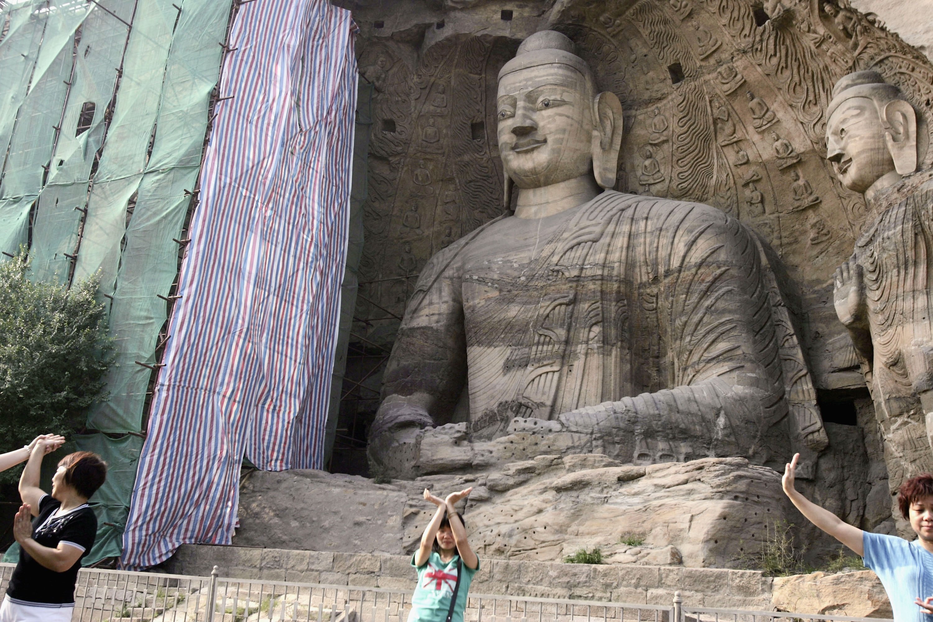 File Visitors view Buddhist sculptures at the Yungang Grottoes on 6 August 2006 in Datong of Shanxi Province, China