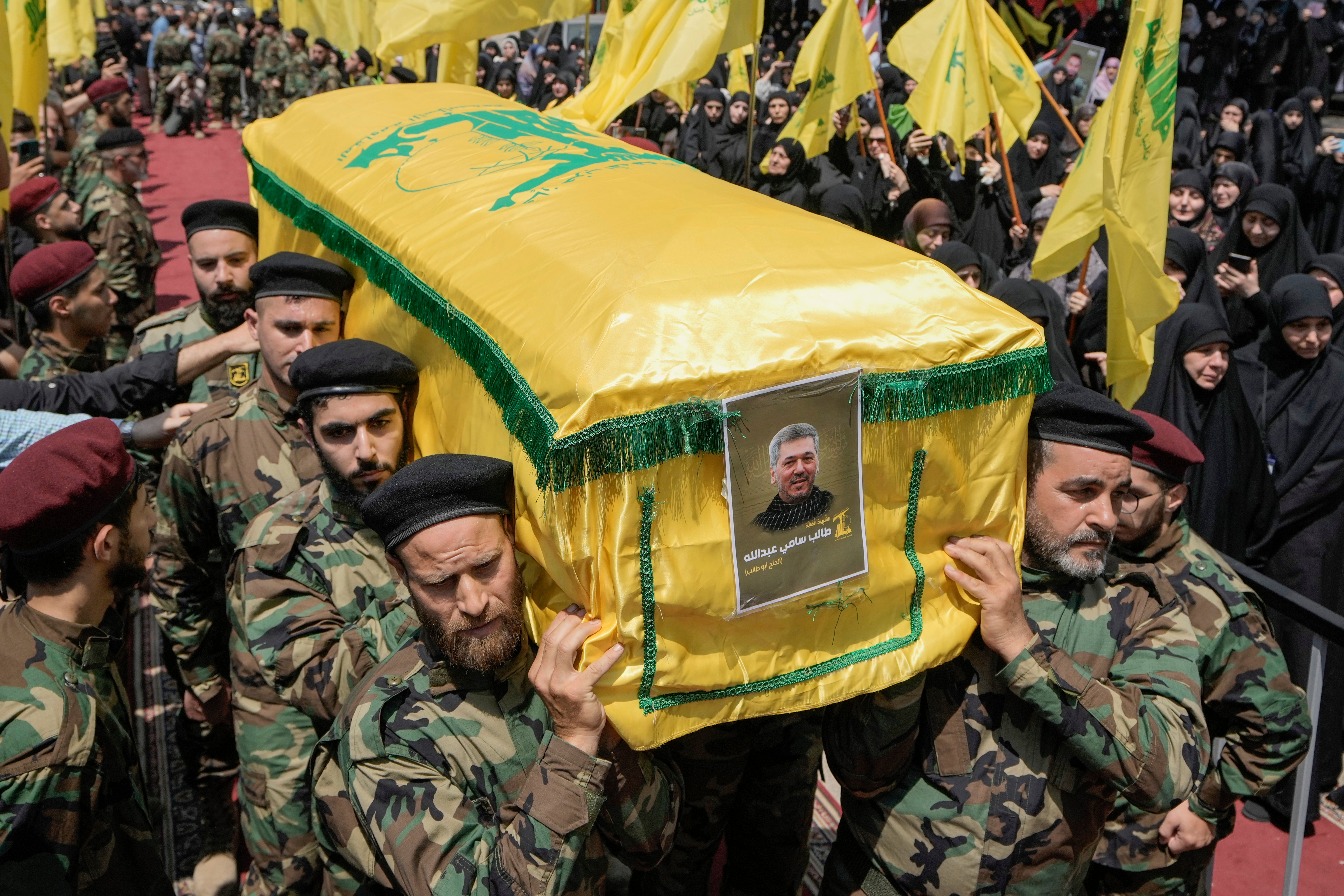 Hezbollah fighters carry the coffin of their comrade, senior commander Taleb Sami Abdullah, 55, known within Hezbollah as Hajj Abu Taleb, who was killed late Tuesday by an Israeli strike in south Lebanon, during his funeral procession in the southern suburbs of Beirut, Lebanon, Wednesday, June 12, 2024