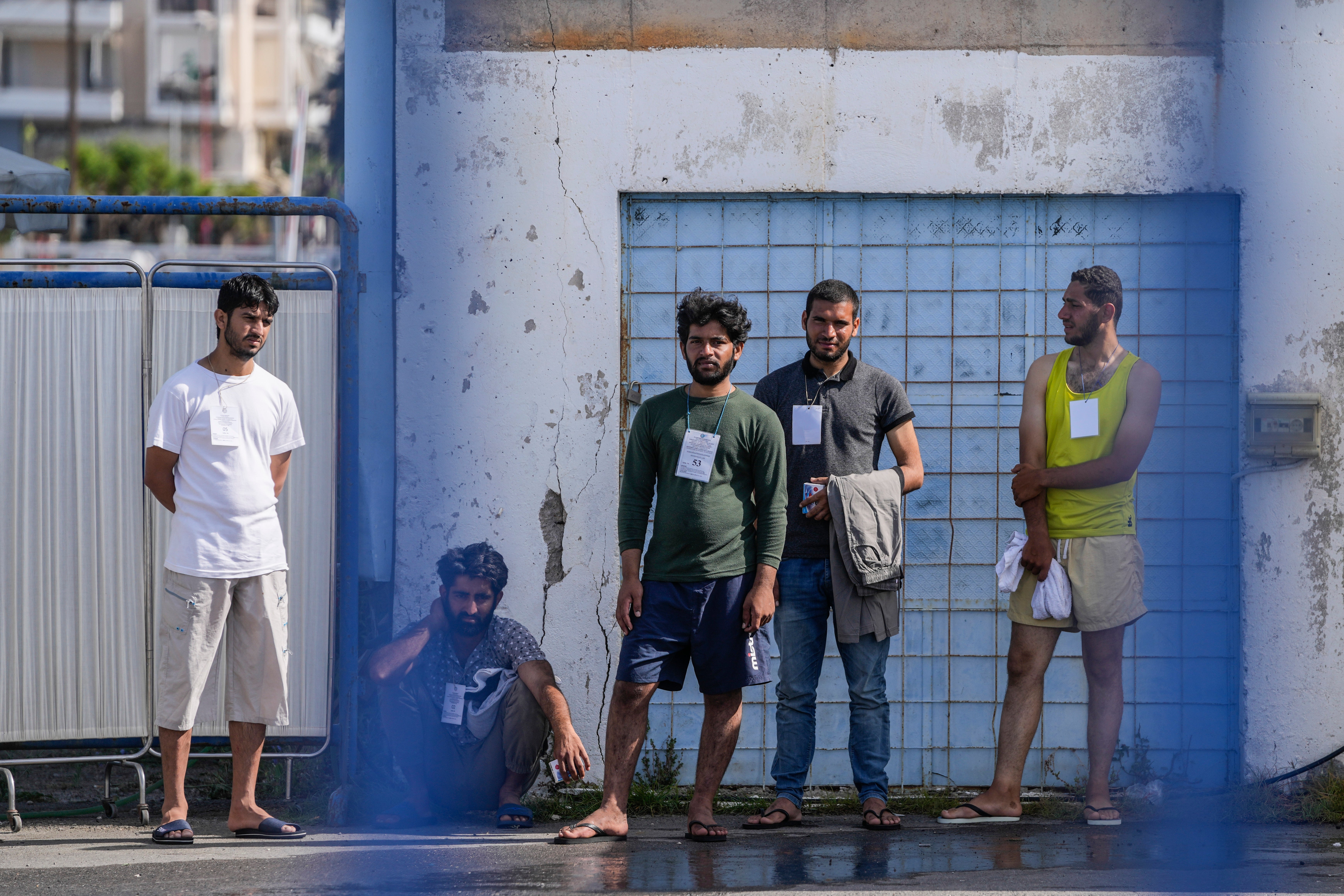 Survivors of a shipwreck stand outside a warehouse at the port in Kalamata town, about 240 kilometers (150miles) southwest of Athens, Greece, Thursday, June 15, 2023