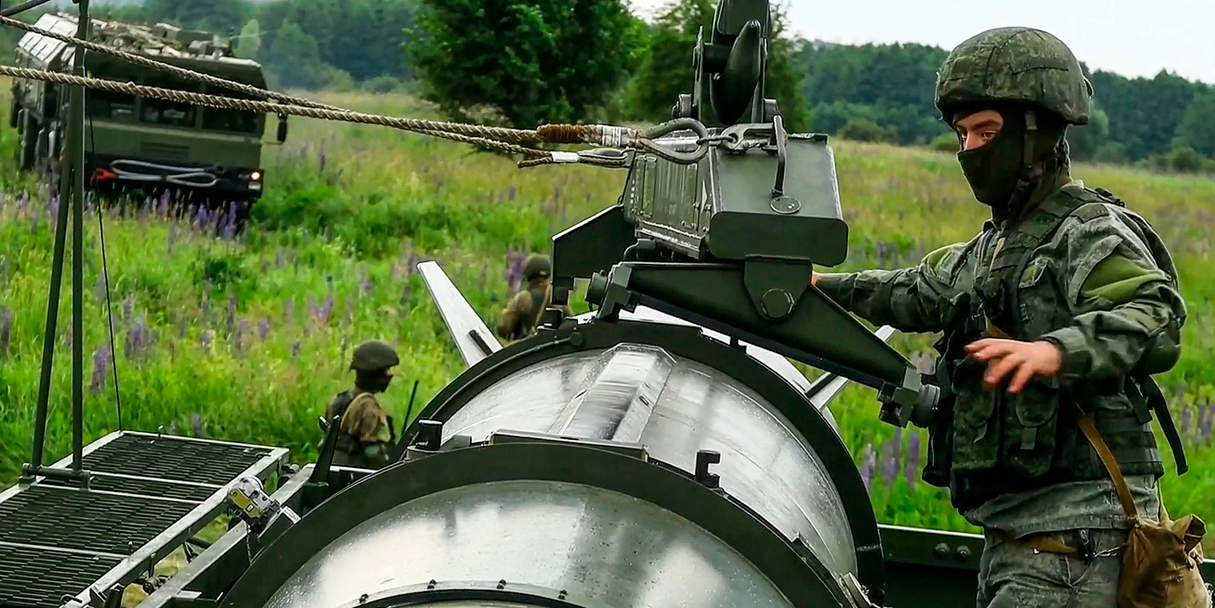 , Russian soldiers load a Iskander-M short-range ballistic missile launchers at a firing position as part of Russian military drill