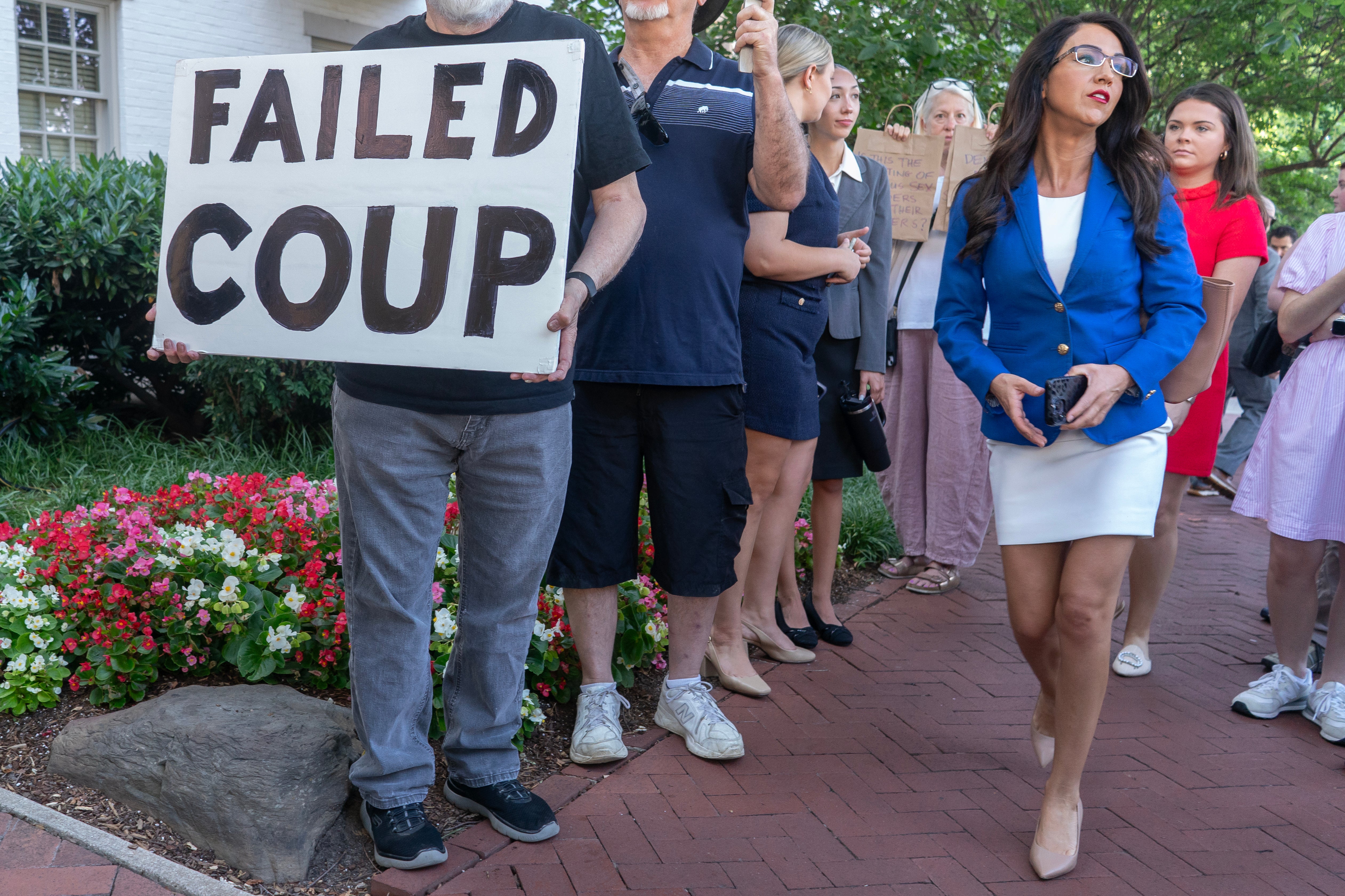 Lauren Boebert walks past a ‘failed coup’ sign on her way to a meeting with House Republicans and Donald Trump at the Capitol Hill Club on June 13.