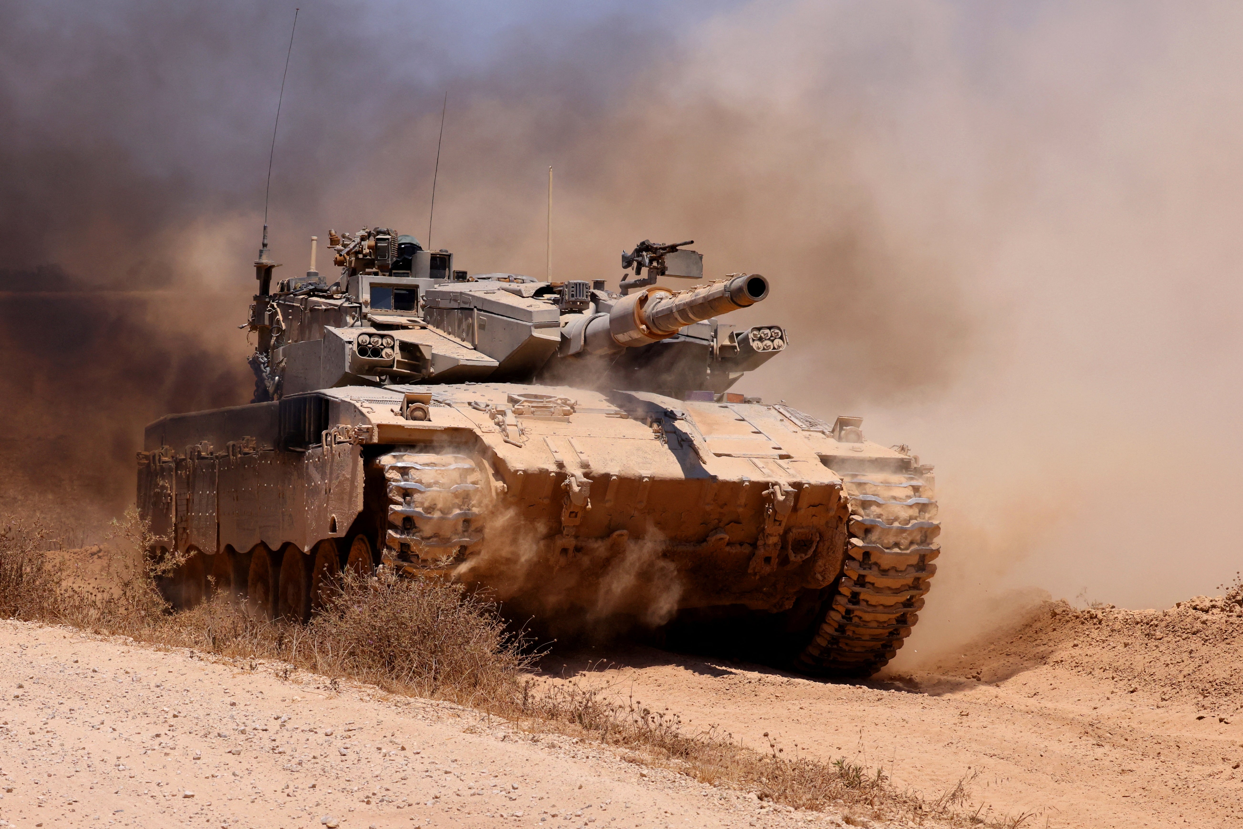 An Israeli army tank rolls along a position in an area of Israel's southern border