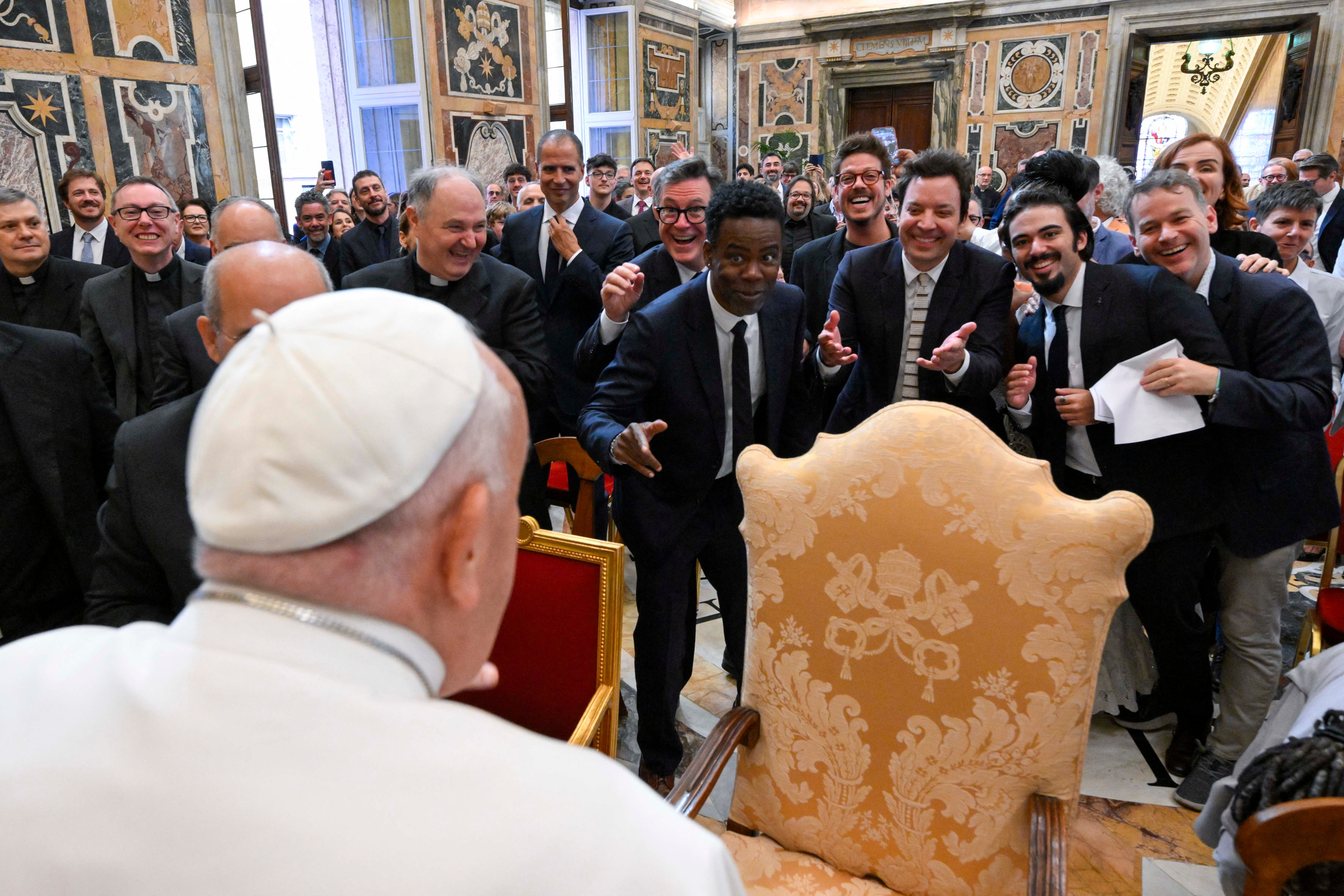 This photo taken and handout on June 14, 2024 by The Vatican Media shows US actors Chris Rock (C), Jimmy Fallon (C right) and Pope Francis during an audience with comedians in The Vatican