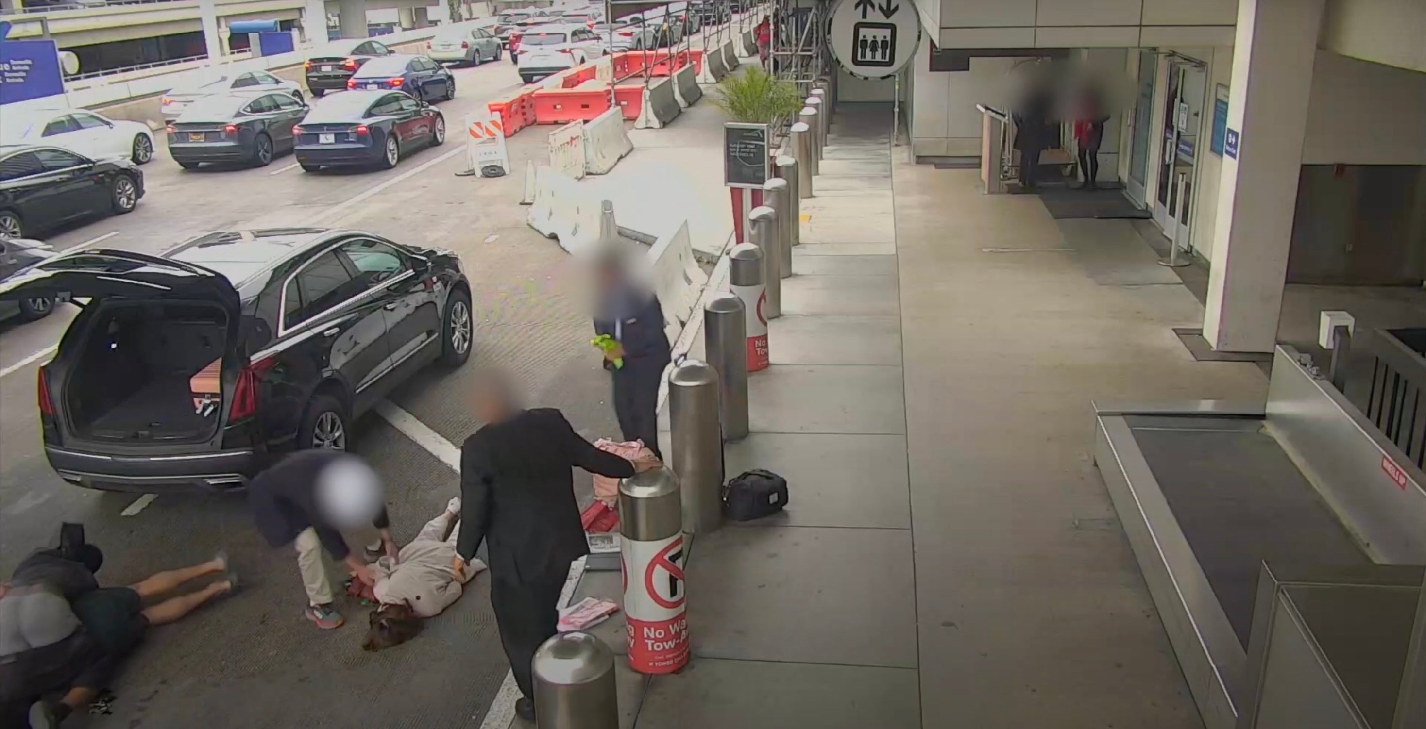 An elderly woman was knocked out when she pushed over by two police in a road-rage fight at Los Angeles International Airport.