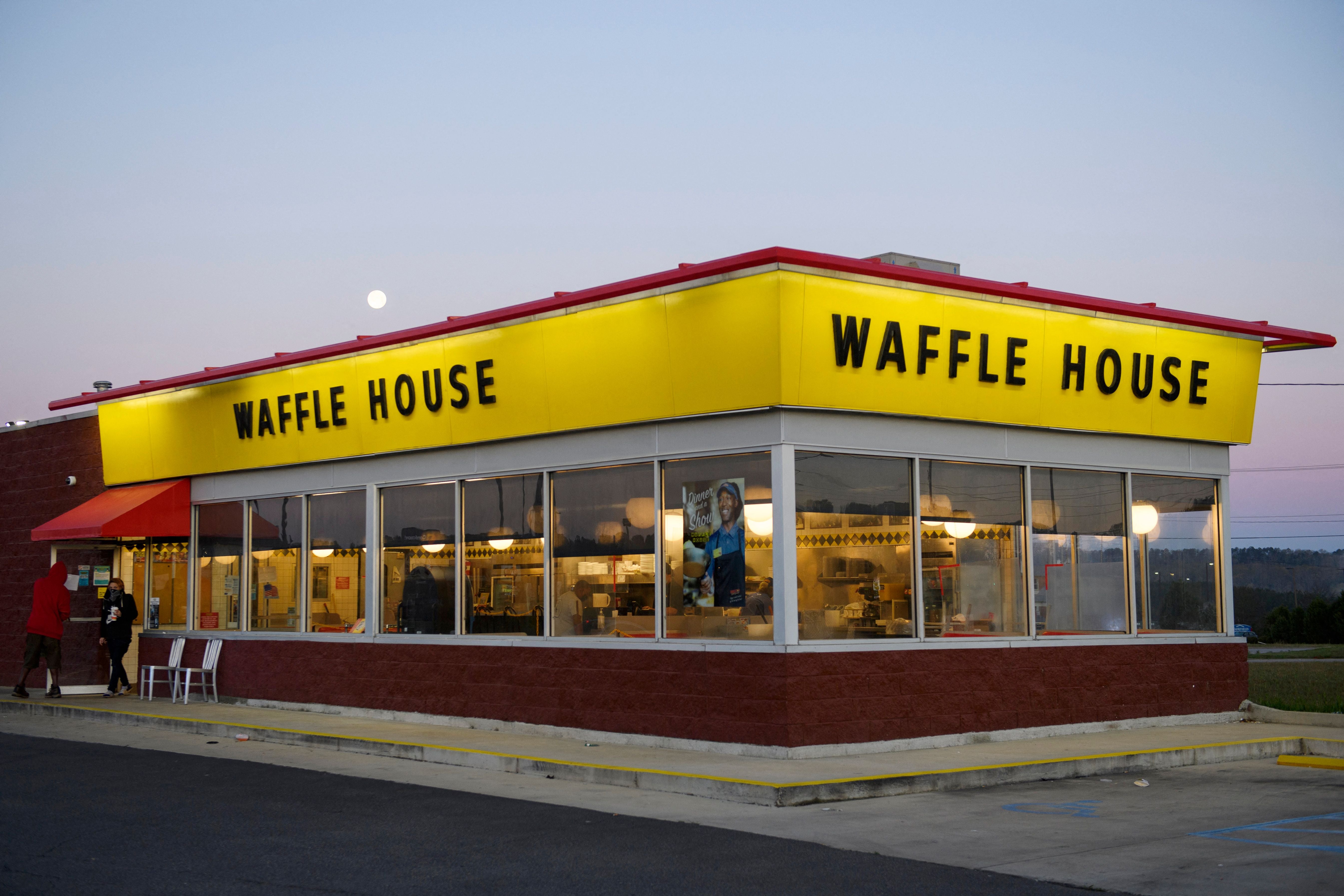 Customers exit a Waffle House restaurant as the moon sets on March 29, 2021 in Bessemer, Alabama