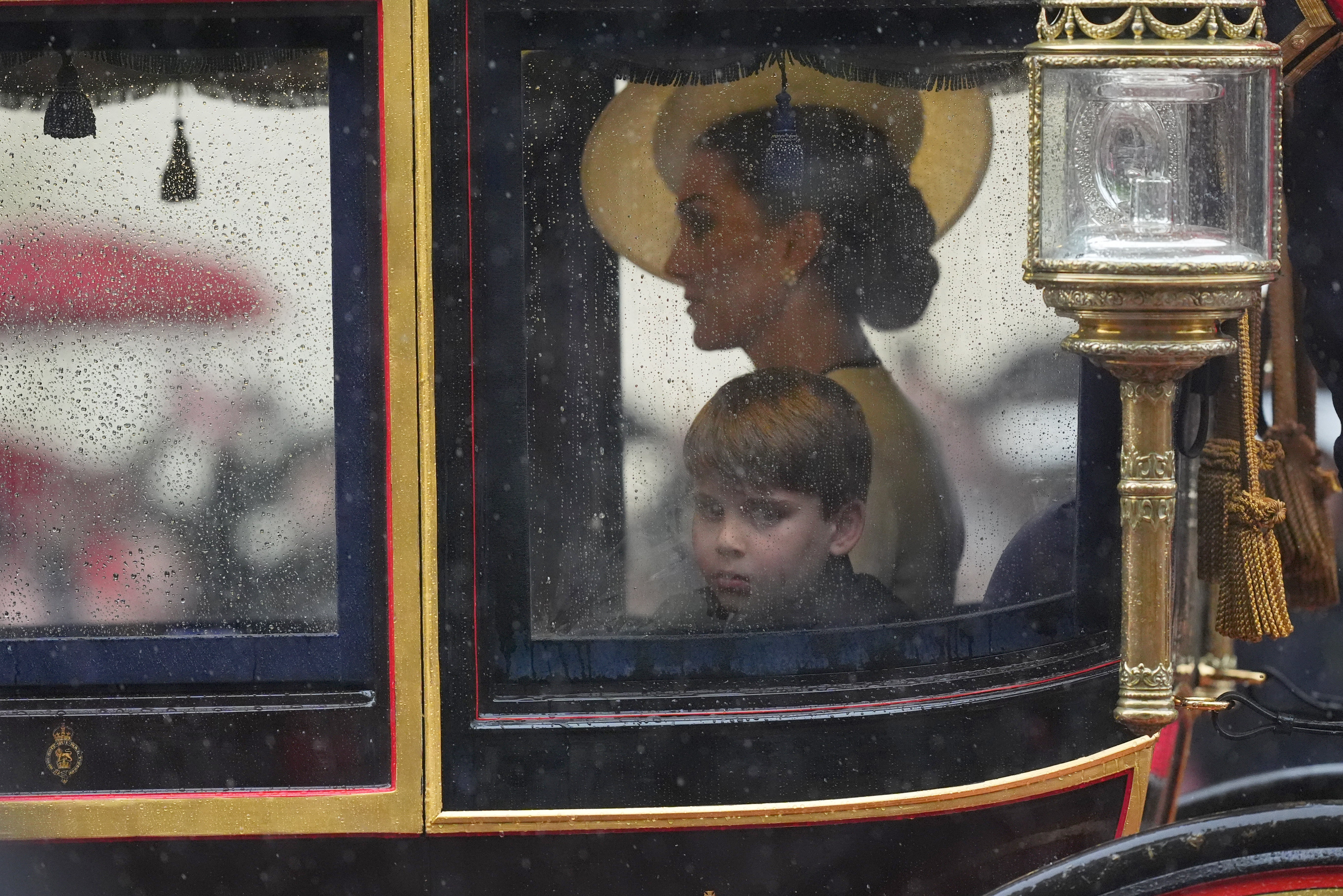 The Princess of Wales and Prince Louis safely in the carriage as they proceed along the rain-soaked Mall