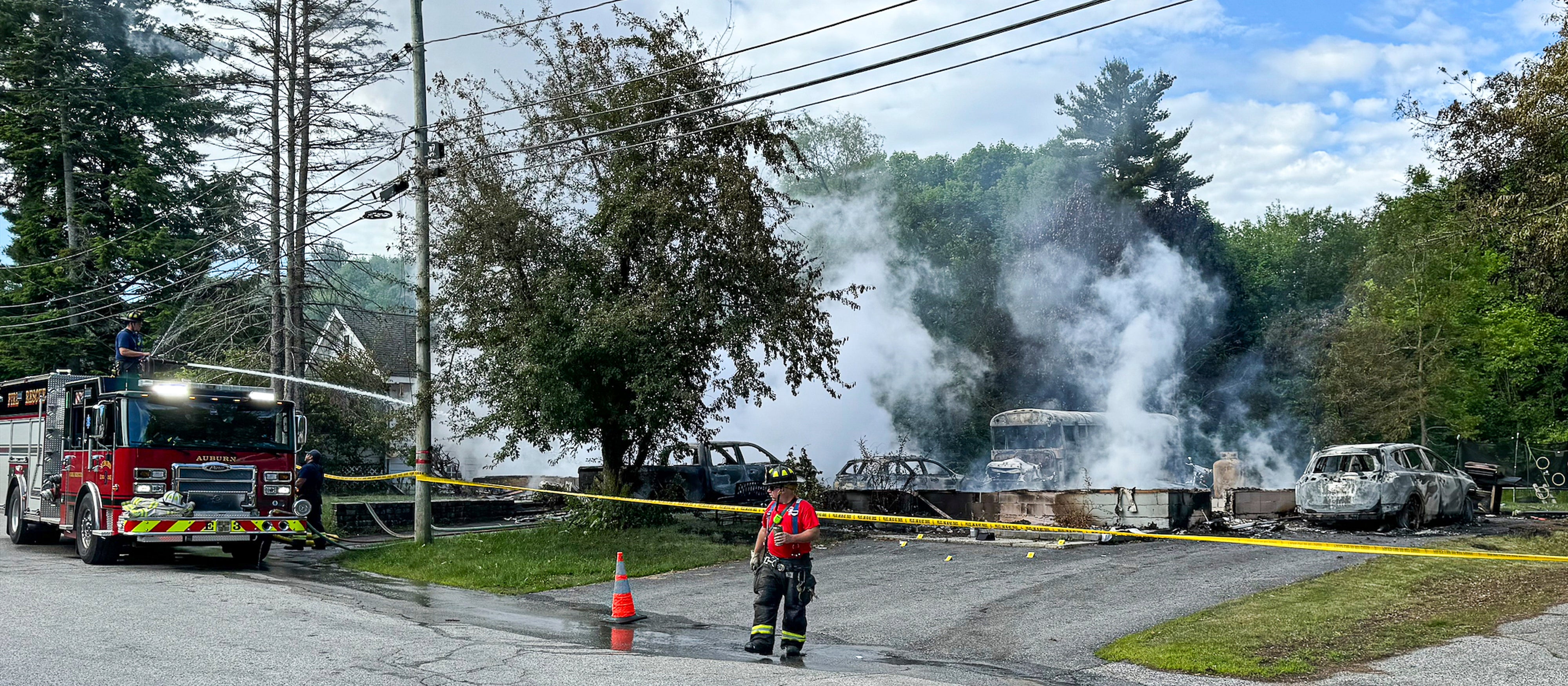 Auburn firefighters hose down the remains of a home in Auburn, Maine, early Saturday. The home went up in flames during a standoff with police