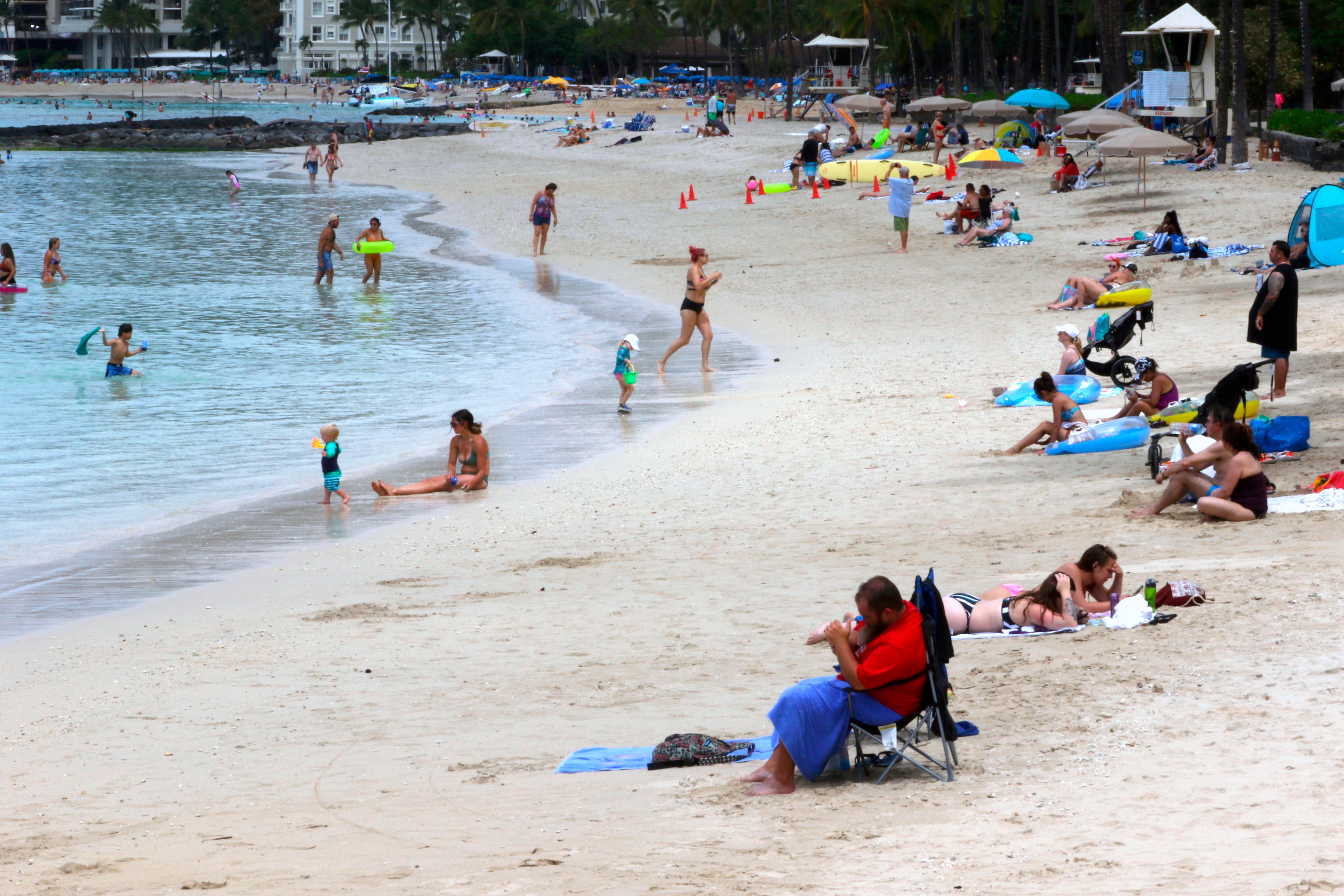 FILE - People sit on Waikiki Beach in Honolulu, Aug. 24, 2021