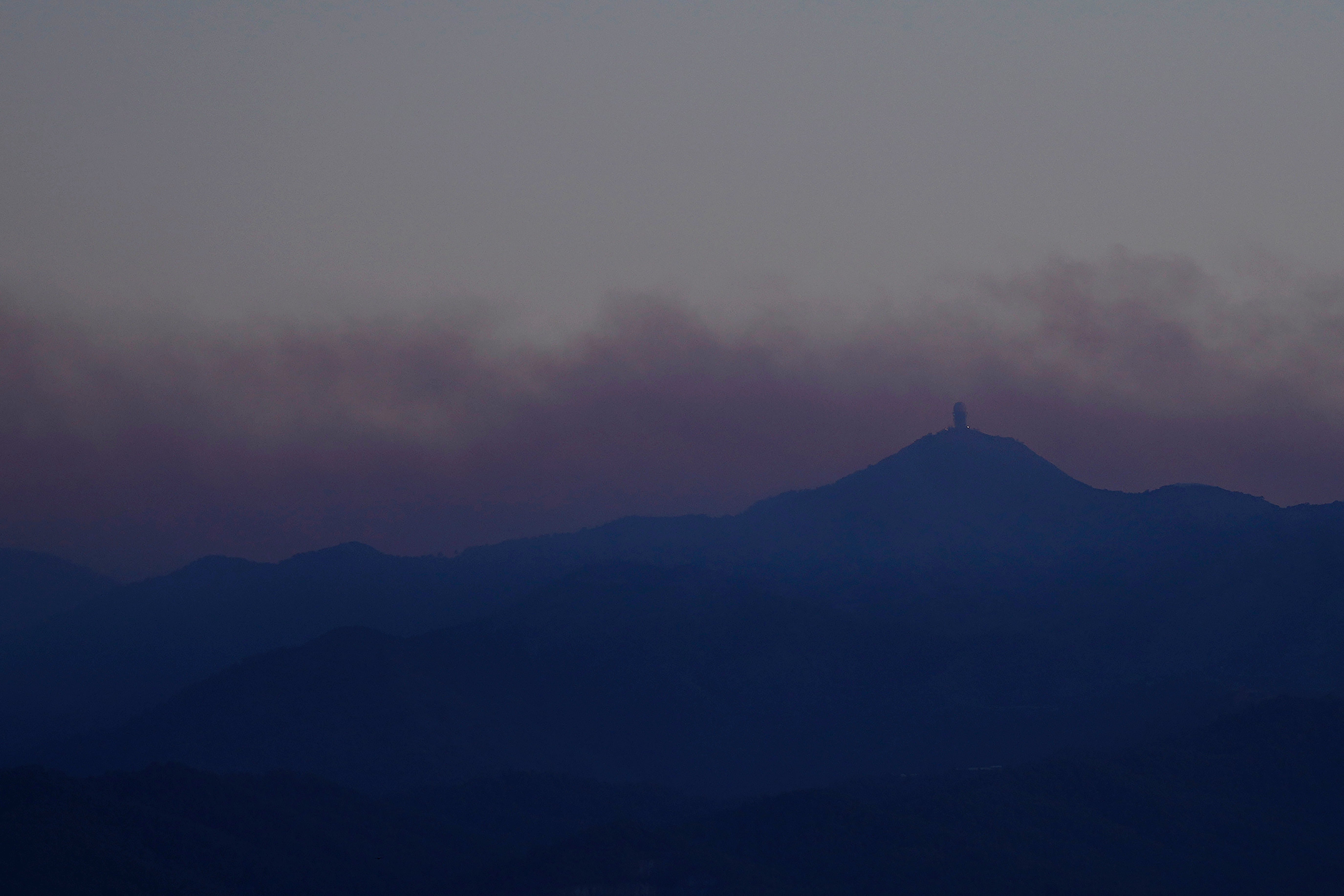 Smoke from a wildfire drifts over Troodos mountain between villages Farmakas and Fikardou in Cyprus